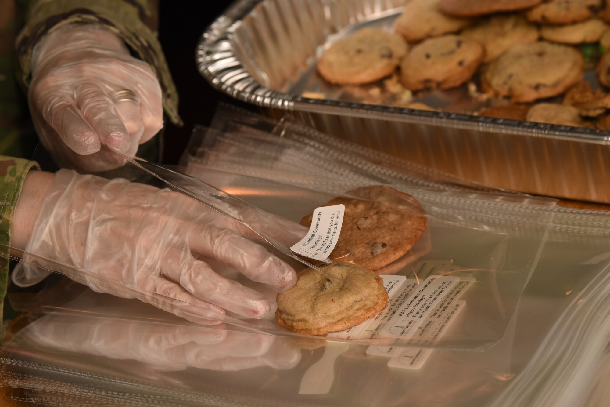 A member of the Liberty Spouses Association packages cookies during a cookie drive at Royal Air Force Lakenheath, England, Dec. 12, 2018. The LSA hosted the Airman Cookie Drive, accepting cookie donations and packaging them for delivery by the First Sergeants Associations to dorm residents. (U.S. Air Force photo by Airman 1st Class Madeline Herzog)