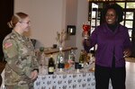 Leslie Noel (right), Joint Base Substance Abuse Program prevention coordinator, demonstrates a standard drink of wine, which is actually water and red dye, that can be consumed in moderation during a talk she gave to military company-level commanders as part of “The Gift of Presence: Resiliency Reset” event at the Vogel Resiliency Center at Joint Base San Antonio-Fort Sam Houston Nov. 30.