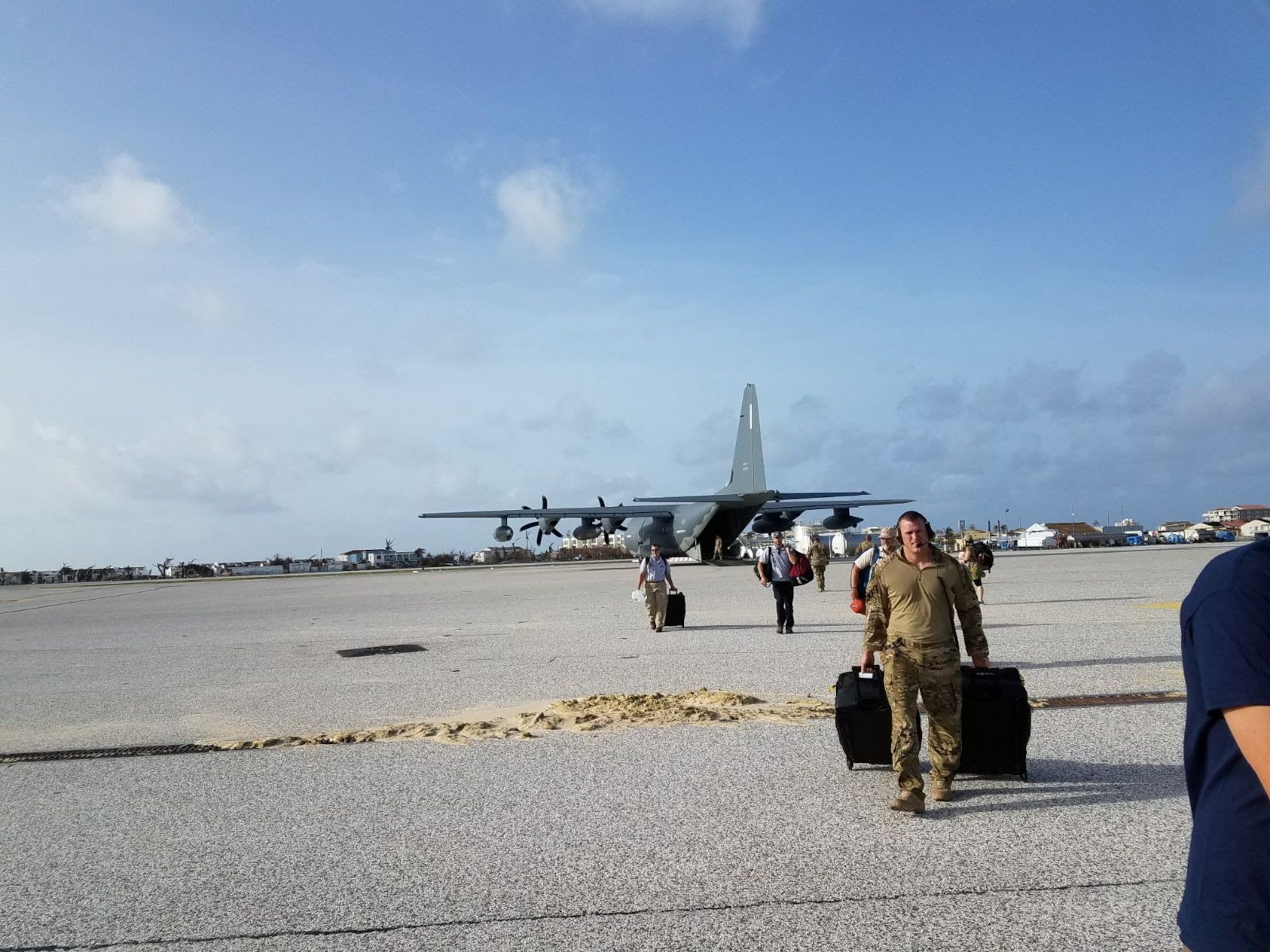 People moving equipment on a flightline