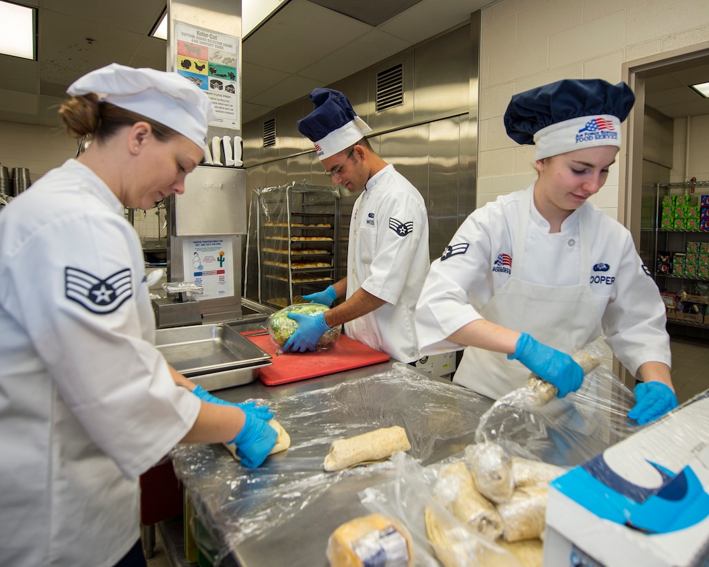 U.S. Air Force Staff Sgt. Janna Turner, left, Senior Airman Christopher Wiese, center, and Airman 1st Class Andrea Cooper, 133rd Force Support Squadron, Sustainment Services Flight, prep food for the Wing holiday meal at the dining facility in St. Paul, Minn., Nov. 11, 2018.