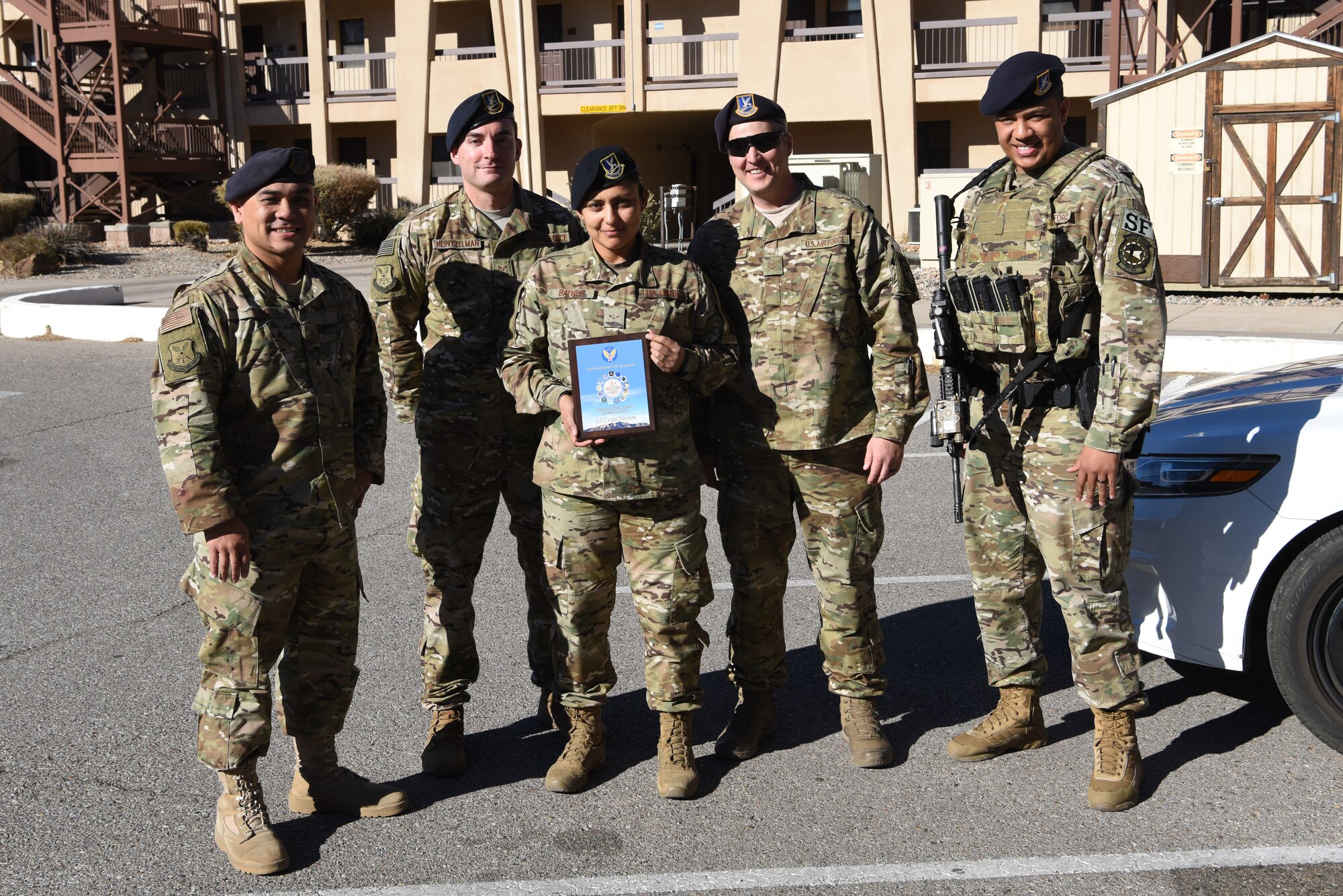 Airman 1st Class Ana Baynes, 377th Security Forces Squadron defender, poses for a photo with her leadership after receiving the November Diamon Sharp Award at Kirtland Air Force Base, N.M., Dec. 13, 2018. Baynes recieved the award for her actions off duty, when she successfully performed the Heimlich maneuver after she saw an elderly man choking. (U.S. Air Force photo by Senior Airman Eli Chevalier)