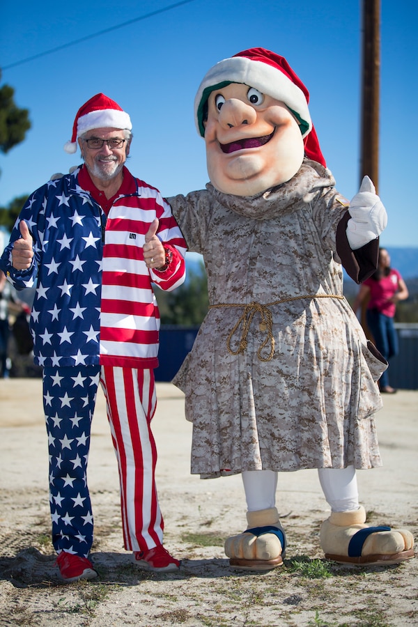 Curt Stanley, left, owner of Adventures in Advertising, and the San Diego Padres team mascot the Swinging Friar, during the Secret Santa event hosted by the Armed Services Young Men’s Christian Association at Marine Corps Base (MCB) Camp Pendleton, California, Dec. 13, 2018. The Secret Santa program gives San Diego County businesses, civic organizations and community members the opportunity to give back to service members stationed at Camp Pendleton by donating gifts to junior enlisted service members families during the holiday season. (U.S. Marine Corps photo by Cpl. Juan Bustos)