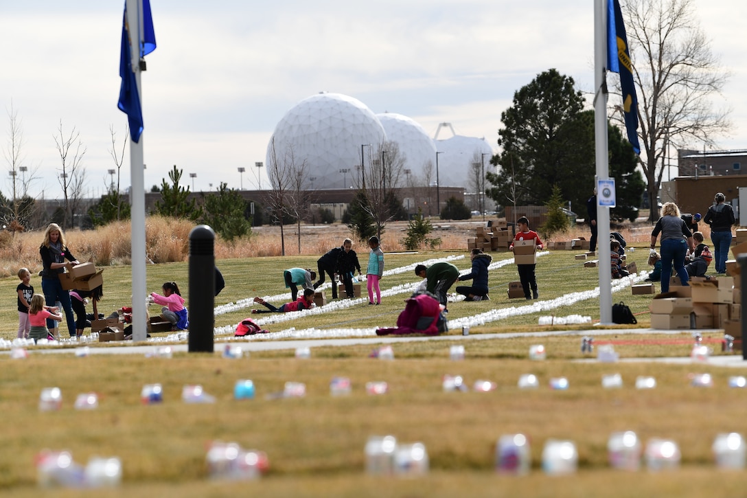 Students and teachers with a Cherry Creek Elementary School and the Aurora Police Department work together to set up luminaries to honor Colorado’s fallen veterans at the Colorado Freedom Memorial in Aurora, Colorado, Nov. 28, 2018.