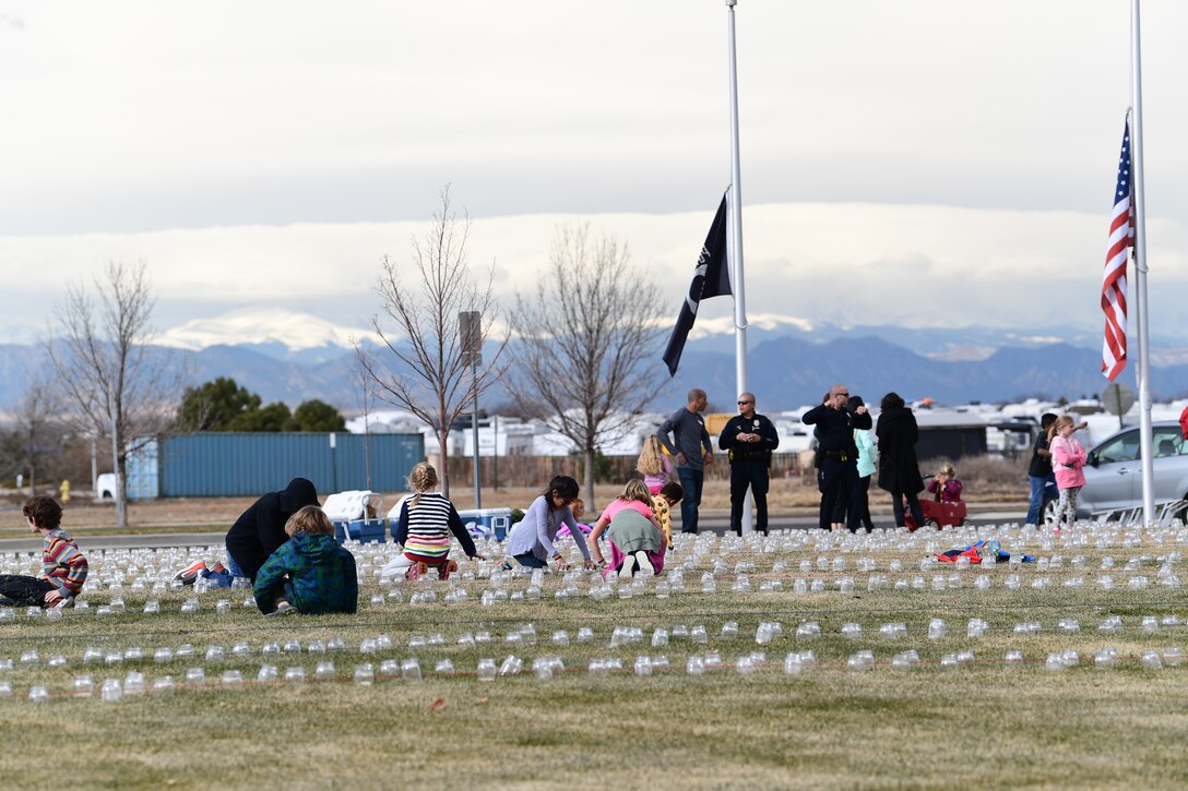 Students and teachers with a Cherry Creek Elementary School and the Aurora Police Department work together to set up luminaries to honor Colorado’s fallen veterans at the Colorado Freedom Memorial in Aurora, Colorado, Nov. 28, 2018.