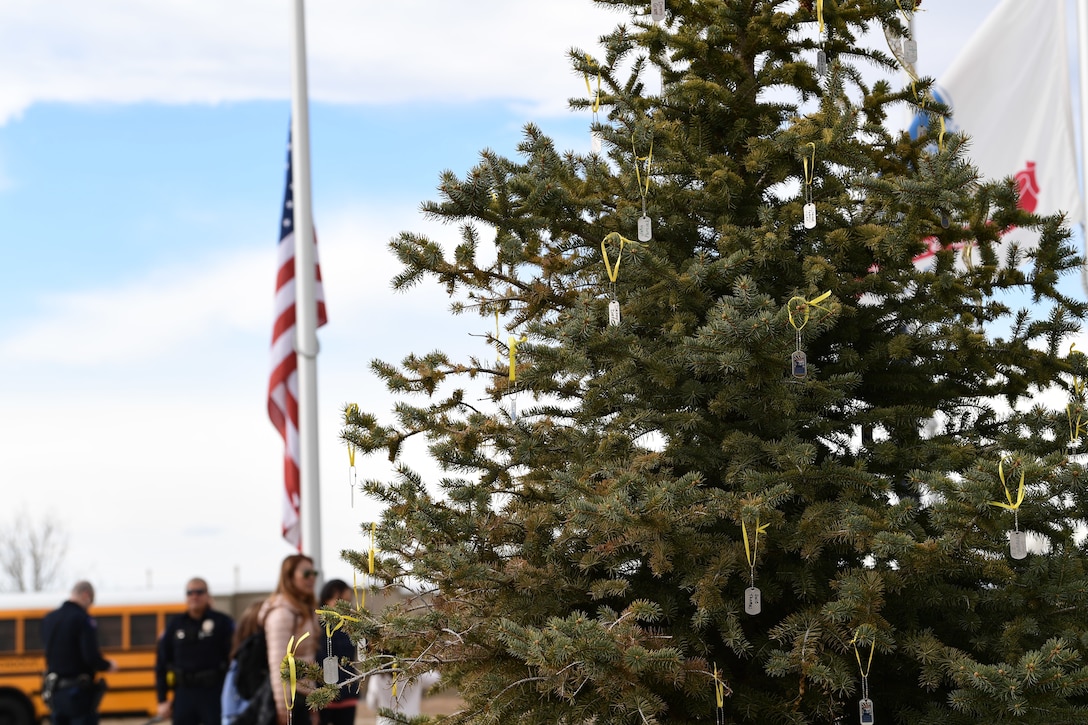 Dog tags hang from yellow ribbon on a pine tree at the Colorado Freedom Memorial in Aurora, Colorado, Nov. 28, 2018.