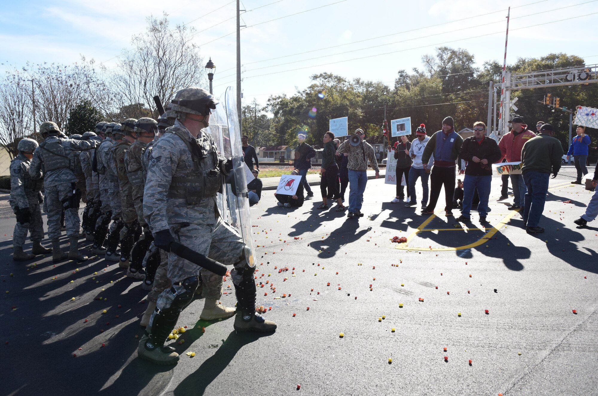 Members of the 81st Security Forces Squadron's riot control team hold the line while being assaulted by fruit thrown by protestors during a 81st SFS protest drill at Keesler Air Force Base, Mississippi, Dec. 12, 2018. The scenario included peaceful protestors expressing their first amendment right that further escalated to a riot when they felt they weren't being heard. The drill, which was a joint effort with the Biloxi Police Department, was conducted to control or prohibit demonstrations and protests. (U.S. Air Force photo by Kemberly Groue)