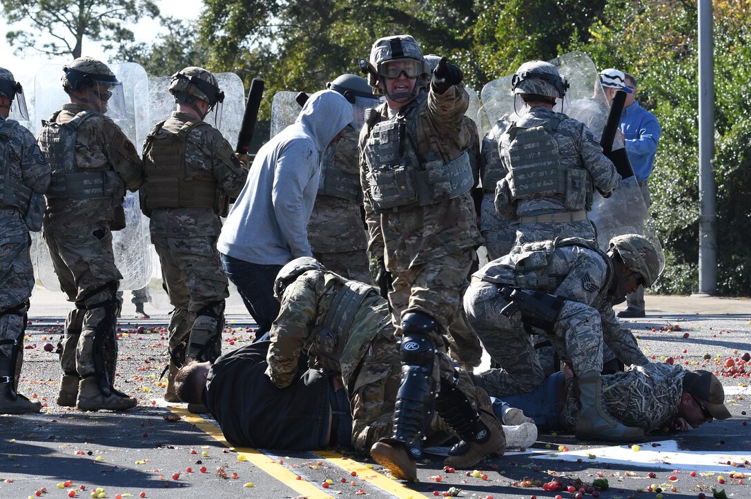 U.S. Air Force Master Sgt. Matthew Oleson, 81st Security Forces Squadron operations NCO in charge, yells out commands as members of the 81st SFS riot control team apprehend protestors during the 81st SFS protest drill at Keesler Air Force Base, Mississippi, Dec. 12, 2018. The scenario included peaceful protestors expressing their first amendment right that further escalated to a riot when they felt they weren't being heard. The drill, which was a joint effort with the Biloxi Police Department, was conducted to control or prohibit demonstrations and protests. (U.S. Air Force photo by Kemberly Groue)