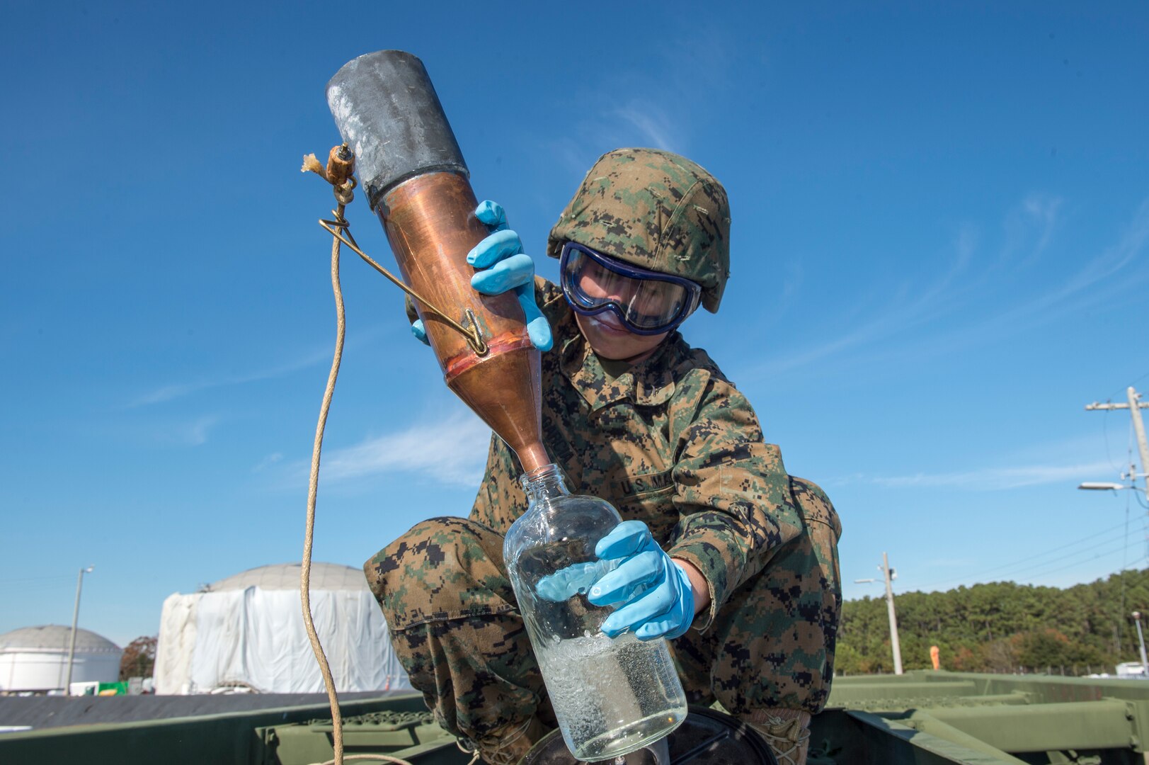 Marine Lance Cpl. Abril Garcia, a bulk fuel specialist from Marine Wing Support Squadron 172, Okinawa, Japan, retrieves a fuel sample during a technical demonstration of the Expeditionary Mobile Fuel Additization Capability at the Charleston Defense Fuel Supply Point Dec. 6, 2018.