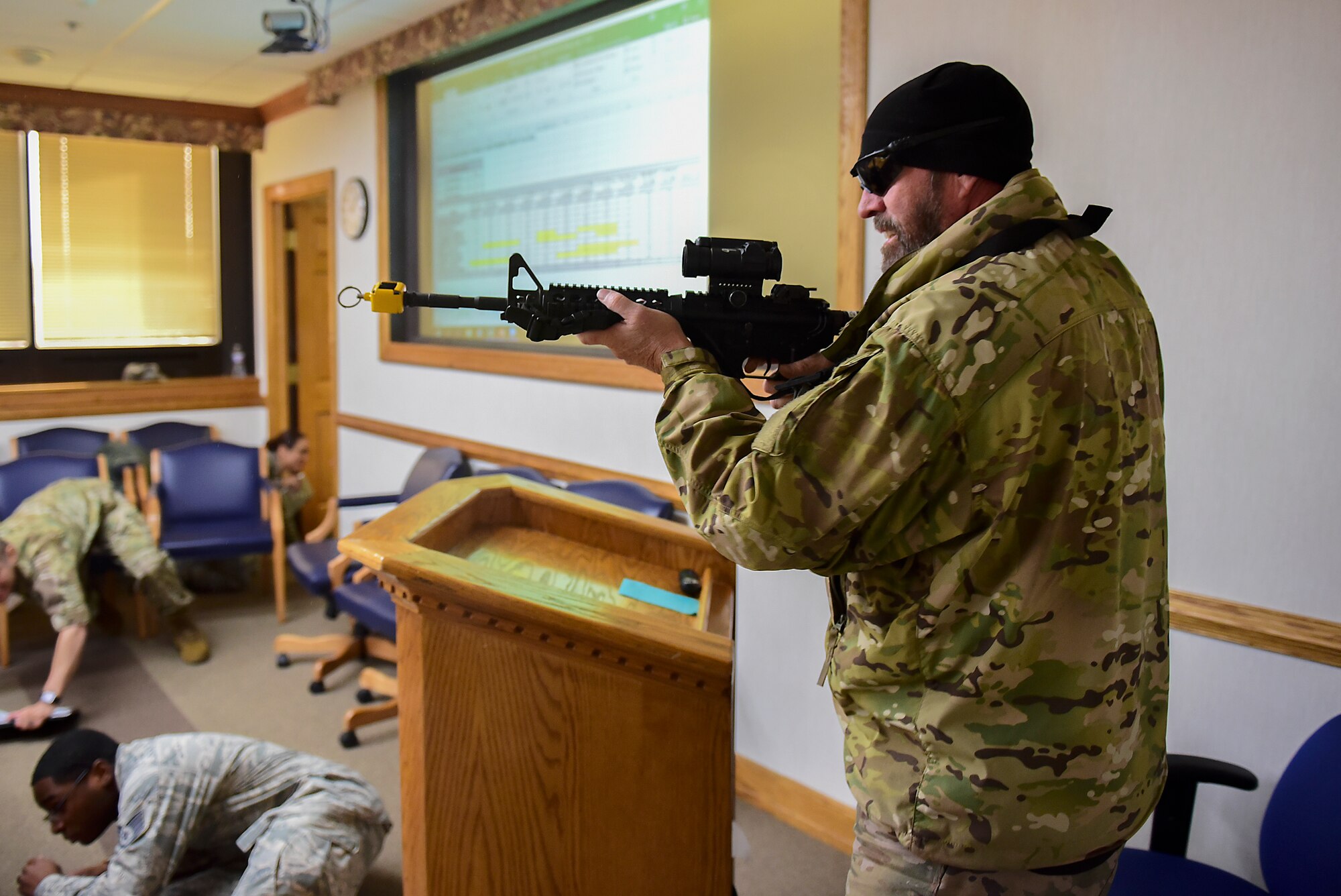 A simulated active shooter fires his weapon in a conference room during a planned exercise Dec. 12, 2018, at Seymour Johnson Air Force Base, North Carolina. During the exercise, the shooter’s weapon used blank rounds which are designed to create a loud sound and flash without a projectile. (U.S. Air Force photo by Senior Airman Kenneth Boyton)