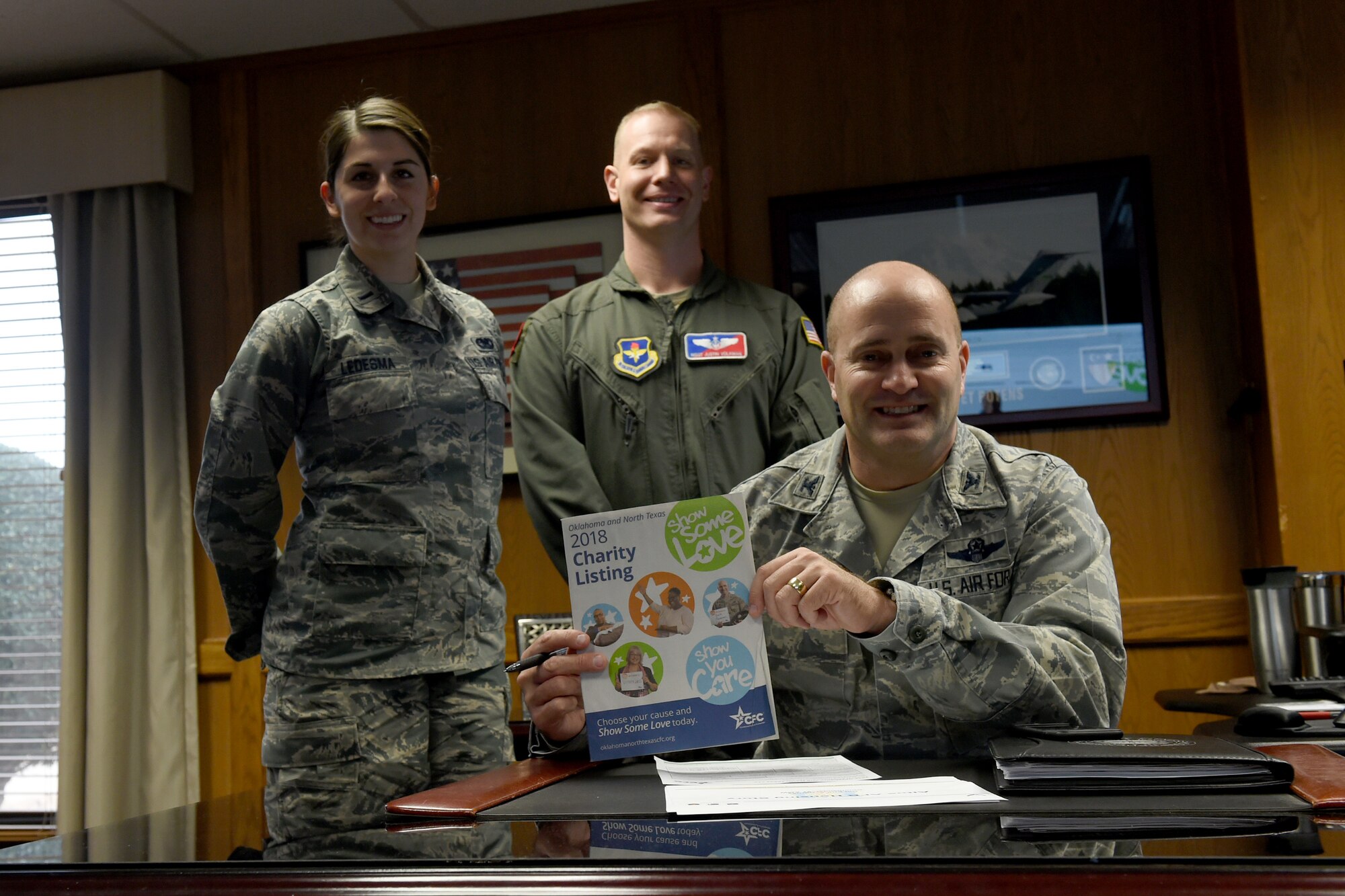 U.S. Air Force Col. Eric Carney, 97th Air Mobility Wing commander, holds the Combined Federal Campaign booklet while the Altus Air Force Base CFC team stands behind him, Dec. 13, 2018, at Altus AFB, Okla. The CFC is the largest and most successful annual workplace charity campaign, raising millions of dollars each year. (U.S. Air Force Photo by Senior Airman Jackson N. Haddon)