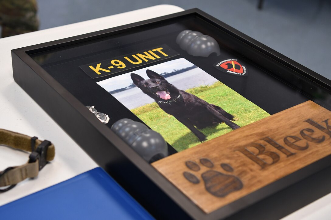 A shadow box is on display during a retirement ceremony for Bleck, 81st Security Forces Squadron military working dog, inside the Larcher Chapel at Keesler Air Force Base, Mississippi, Dec. 13, 2018. Bleck was accepted into military service August 2010, became fully certified as a patrol and drug detector dog in March 2011, and was assigned to Keesler shortly after. (U.S. Air Force photo by Airman 1st Class Suzie Plotnikov)