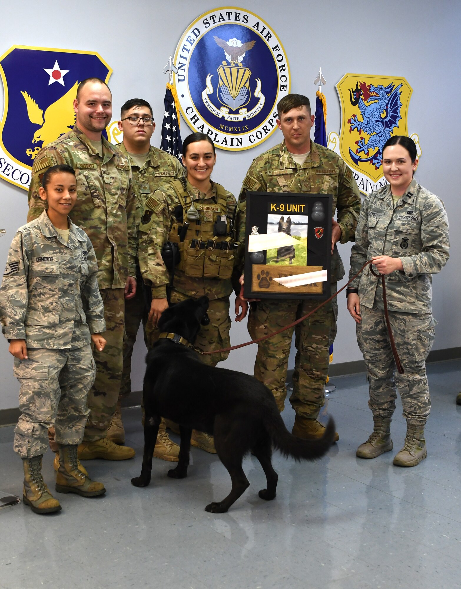The 81st Security Forces Squadron military working dog section presents a shadow box to Bleck, 81st SFS MWD, during Bleck's retirement ceremony at Keesler Air Force Base, Mississippi, Dec. 13, 2018. After serving eight years and working alongside 11 handlers during his career, he was adopted by Giebel. (U.S. Air Force photo by Airman 1st Class Suzie Plotnikov)