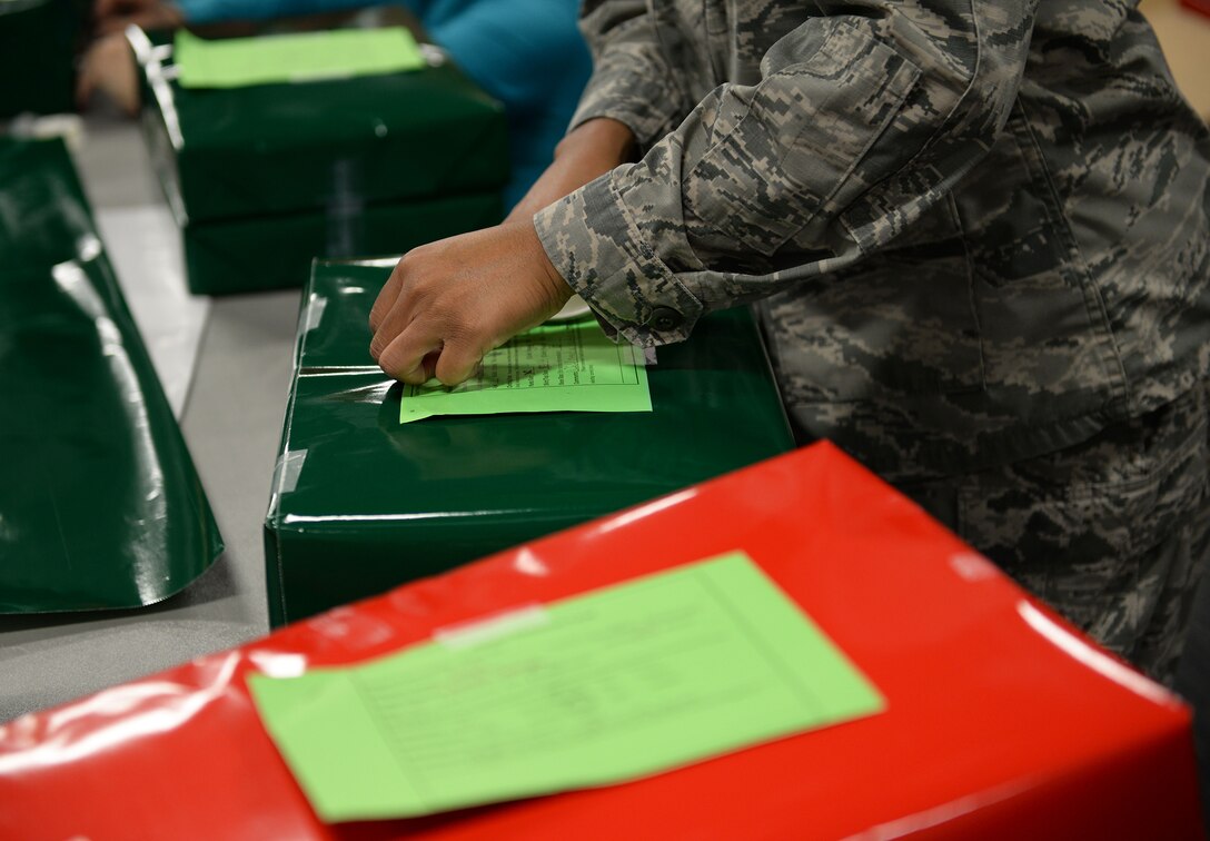 An Airman attaches an address label to a present during the Happy Irby Fund Shop and Wrap at the Club Dec. 12, 2018, on Columbus Air Force Base, Mississippi. The Happy Irby Shop and Wrap provides underprivileged children with wrapped presents containing basic necessities such as clothing. (U.S. Air Force photo by Airman Hannah Bean)