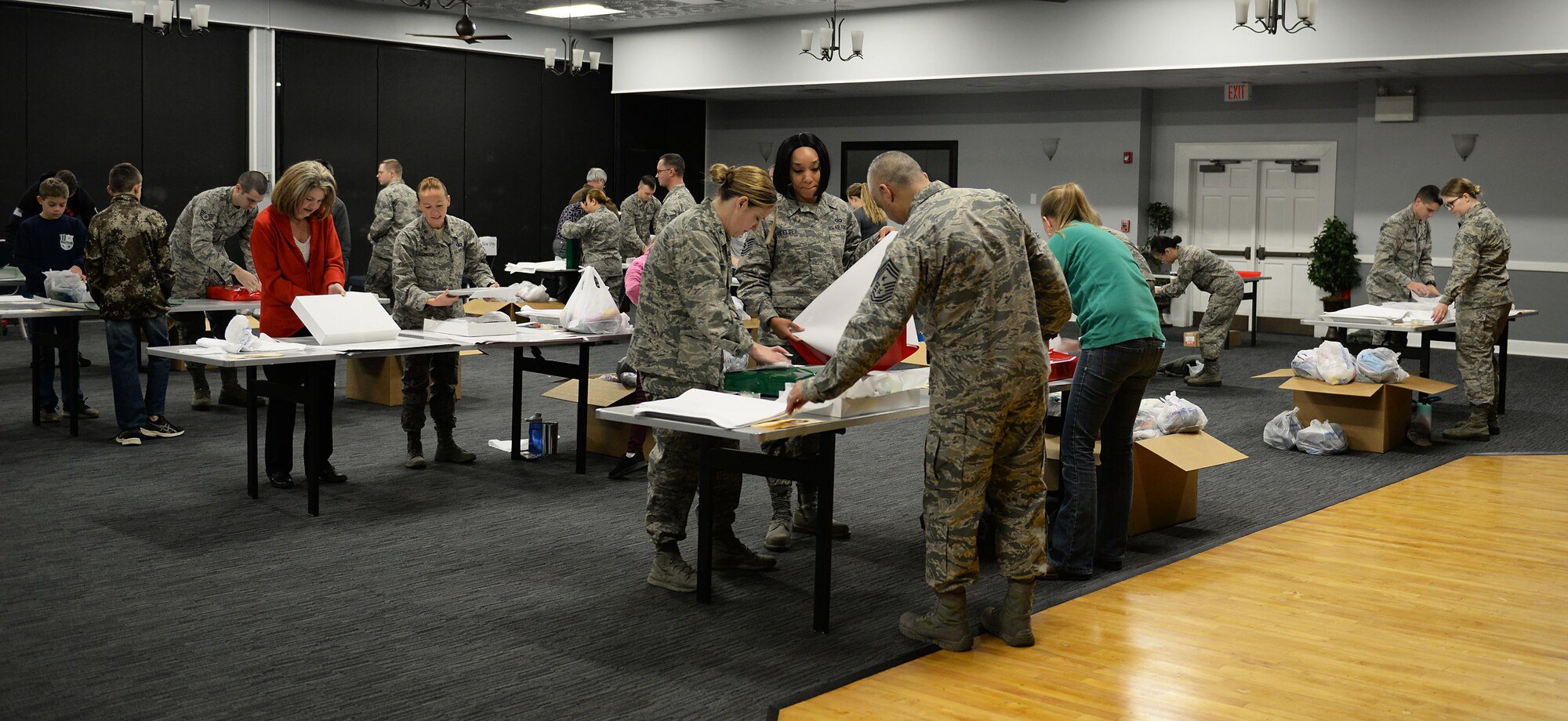 Members of Team BLAZE wrap gifts during the Happy Irby Fund Shop and Wrap at the Club Dec. 12, 2018, on Columbus Air Force Base, Mississippi. Over 350 gifts were filled, wrapped and sent to local schools in the Lowndes County area. (U.S. Air Force photo by Airman Hannah Bean)