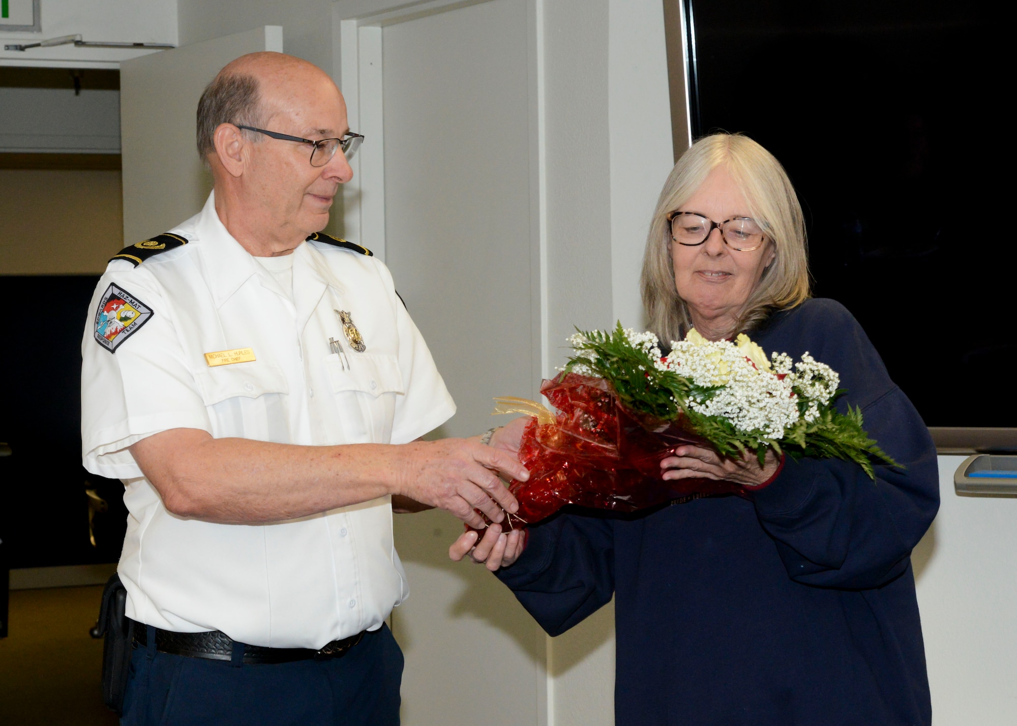 Retiring Fire Chief, Michael Hurles, presents flowers to his wife, Tammy, thanking her for her support during his retirement ceremony at Edwards Air Force Base, California, Dec. 14. Hurles retired after 42 years of service. (U.S. Air Force photo by Giancarlo Casem)
