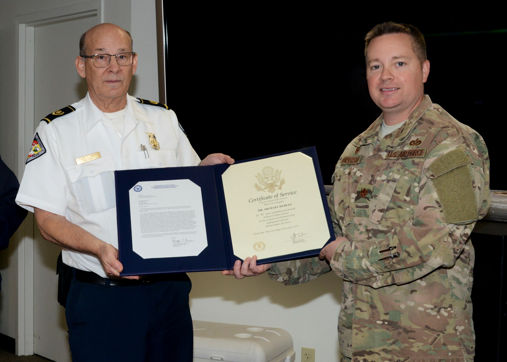 Retiring Fire Chief, Michael Hurles,receives his certificate of retirement from Maj. Brian Anderson, 812th Civil Engineer Squadron commander, during a retirement ceremony at Edwards Air Force Base, California, Dec. 14. Hurles retired after 42 years of service. (U.S. Air Force photo by Giancarlo Casem)