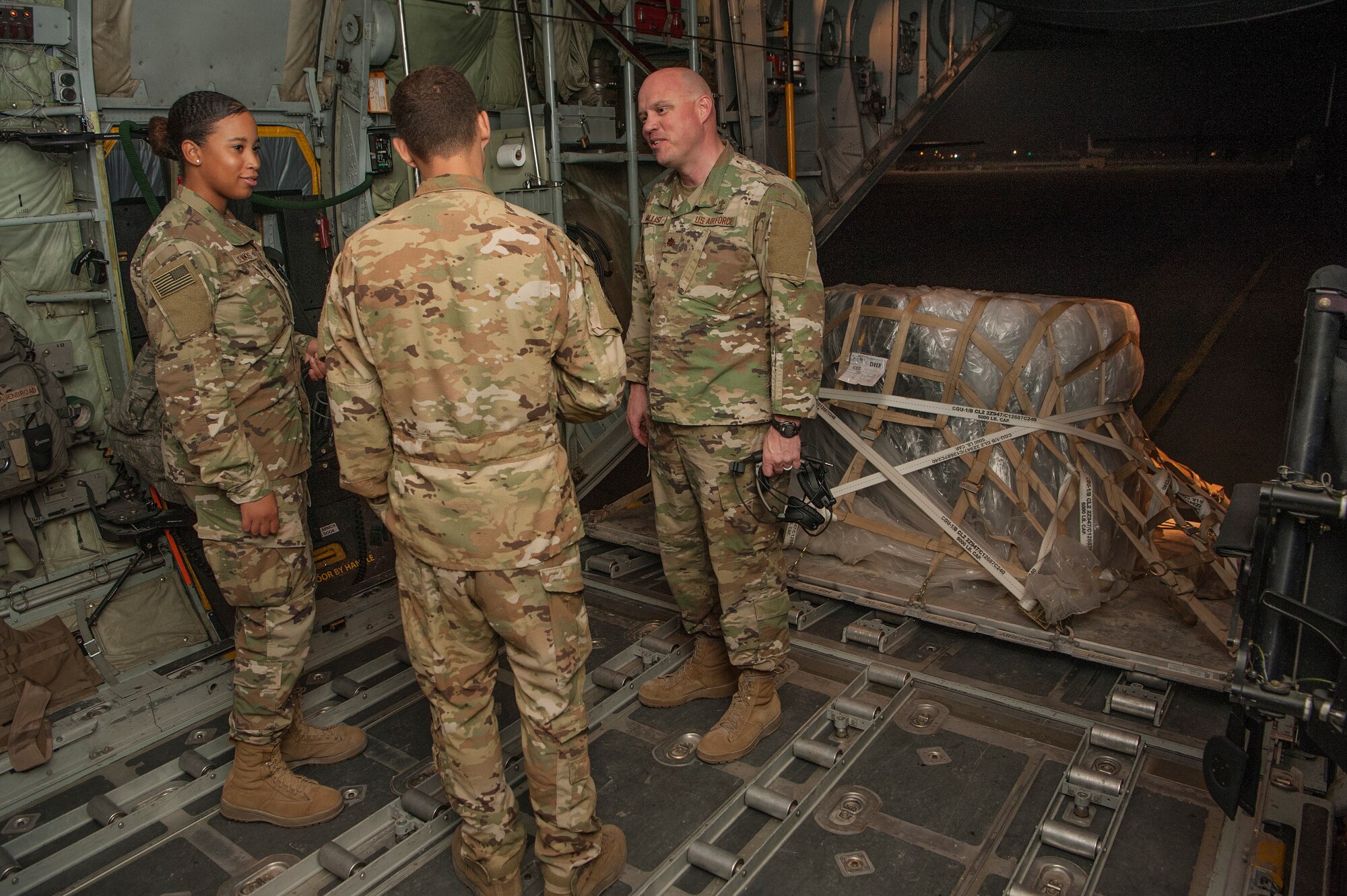 Chaplain (Maj.) Cody Hollist, right, and Staff Sgt. Daneasha Jenkins, left, both assigned to the 379th Air Expeditionary Wing (AEW) chapel office, talk with Staff Sgt. Chris Brassard, center, 746th Expeditionary Airlift Squadron loadmaster, on a C-130 Hercules prior to takeoff Dec. 15, 2018, at Al Udeid Air Base, Qatar.