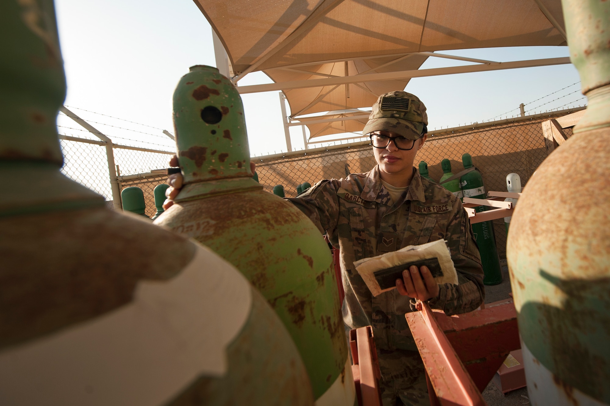 Senior Airman Erica Garcia, 379th Expeditionary Logistics Readiness Squadron hazardous material (HAZMAT) pharmacy technician, checks tank information at the HAZMAT pharmacy cylinder yard Dec. 13, 2018, at Al Udeid Air Base, Qatar.