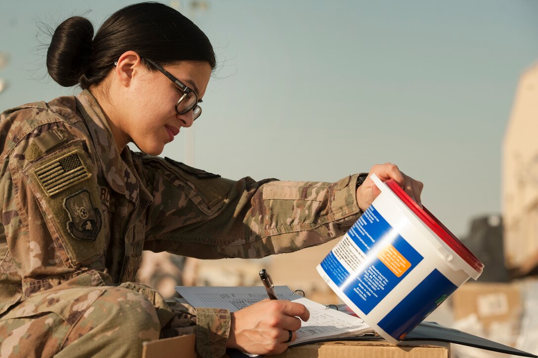 Senior Airman Erica Garcia, 379th Expeditionary Logistics Readiness Squadron hazardous material (HAZMAT) pharmacy technician, picks up HAZMAT orders at the Transportation Management Office Dec. 13, 2018, at Al Udeid Air Base, Qatar.