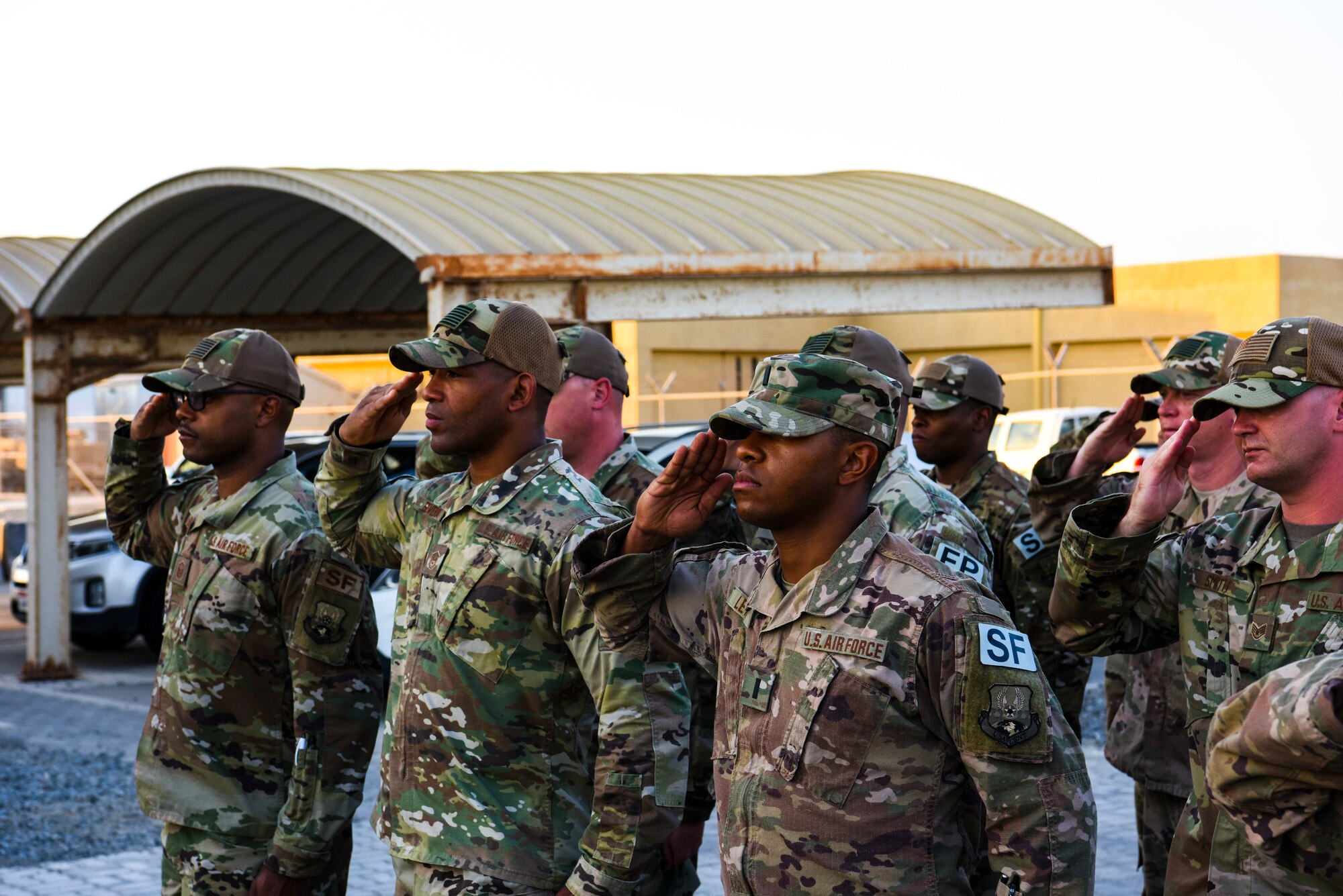 Airmen assigned to the 380th Expeditionary Security Forces squadron render a salute during The National Anthem played at a monthly retreat ceremony at Al Dhafra Air Base, United Arab Emirates, Dec. 7, 2018.