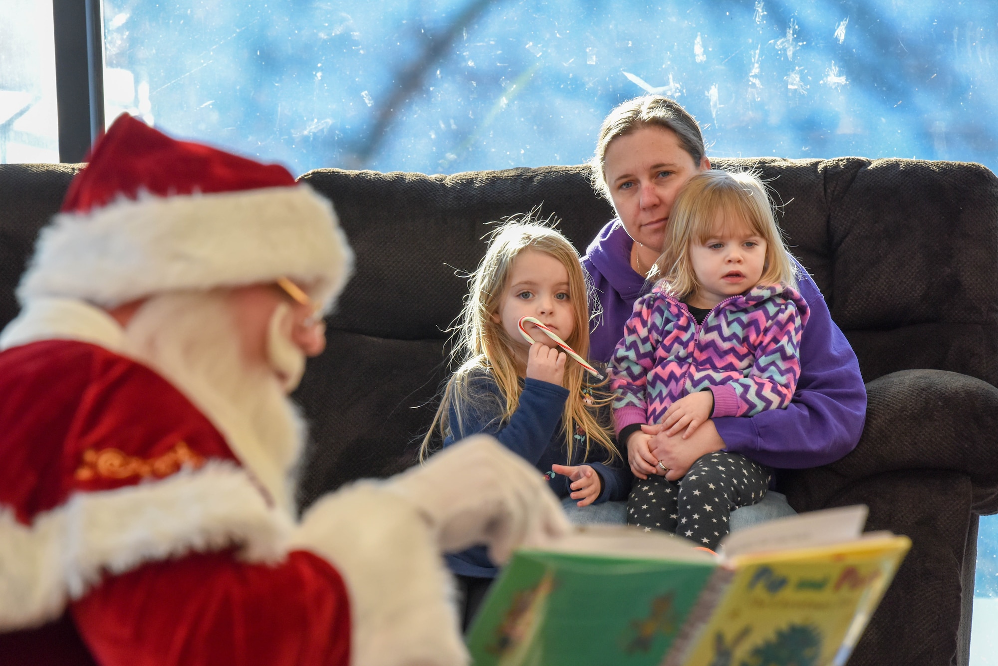 Santa Claus reads “Pip and Posy” to children in the Holbrook Library on Ellsworth Air Force Base, S.D., Dec. 13, 2018. Santa’s operations stretch across the globe, but even with his busy schedule, he still finds time to interact with children on a personal level. (U.S. Air Force photo by Tech. Sgt. Jette Carr)
