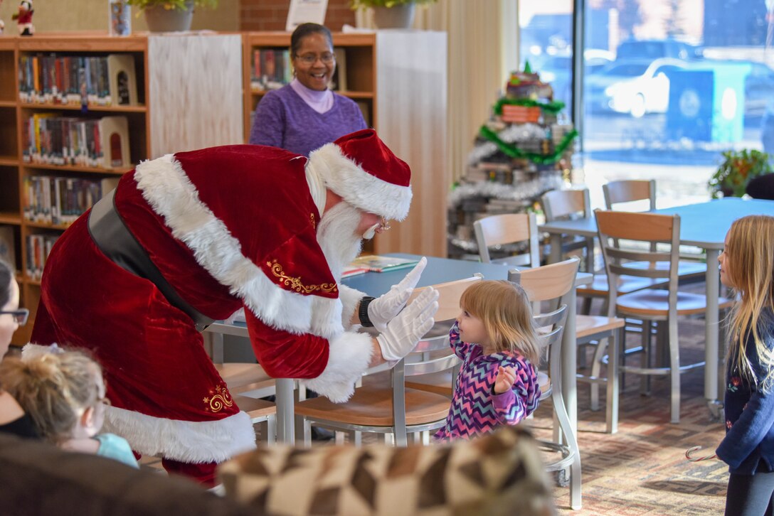 Santa Claus gives out high fives to kids at the Holbrook Library on Ellsworth Air Force Base, S.D., Dec. 13, 2018. Father Christmas visited the base to read a book with the good boys and girls of Ellsworth AFB. (U.S. Air Force photo by Tech. Sgt. Jette Carr)