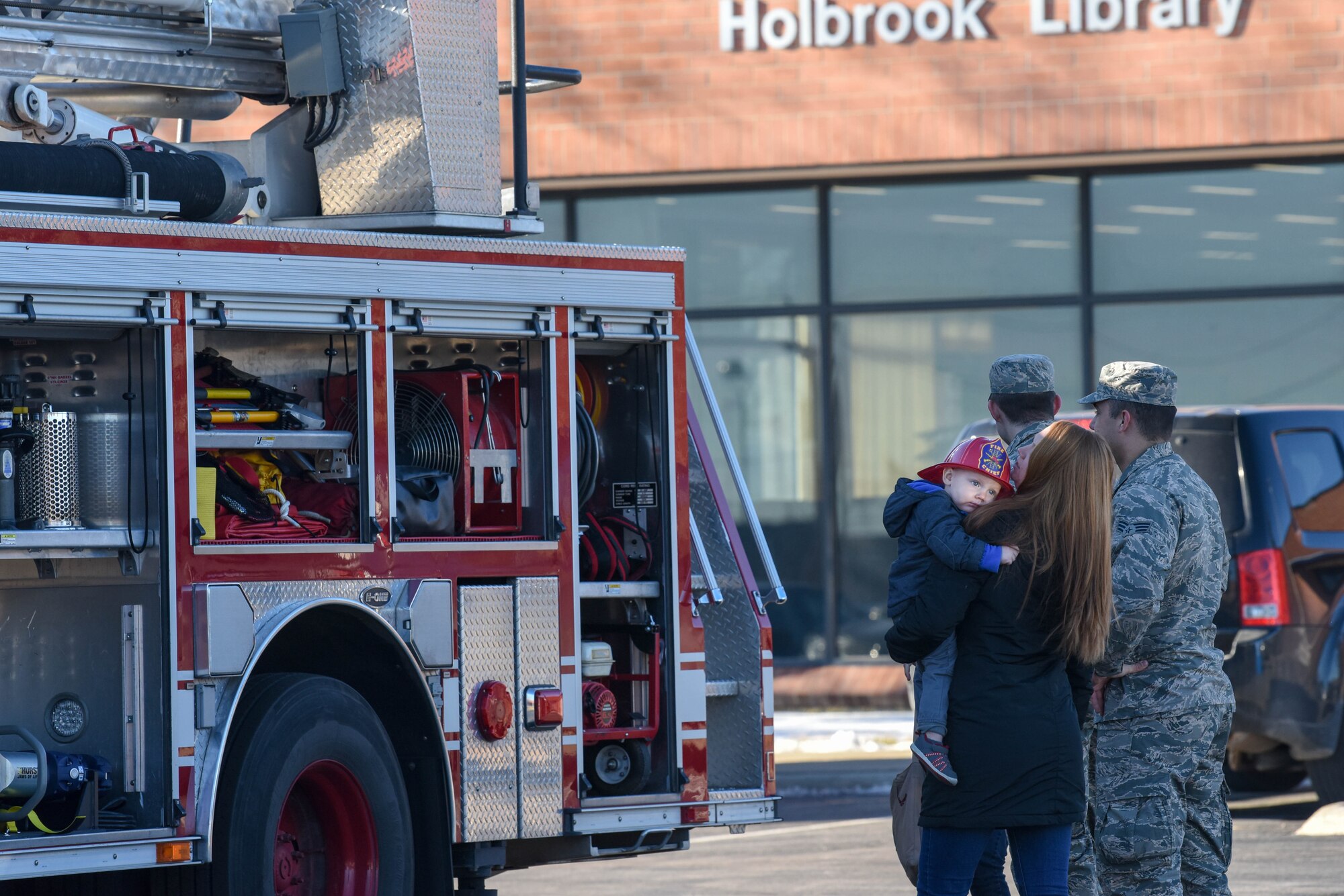 Airmen and their families are shown the different components of a fire truck following the “Santa and Me Story Time” event at the Holbrook Library on Ellsworth Air Force Base, S.D., Dec. 13, 2018. The 28th Civil Engineer Squadron Fire Department escorted Santa Claus to the library, where he visited with the base’s children and read a holiday story. (U.S. Air Force photo by Tech. Sgt. Jette Carr)