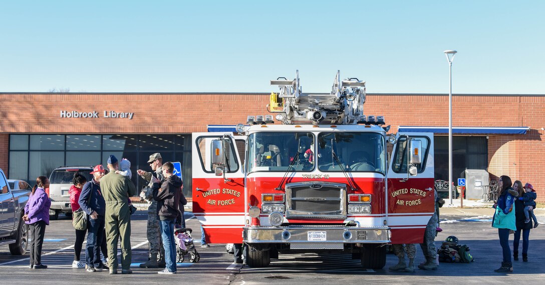 Members of the 28th Civil Engineer Squadron Fire Department visit with families on Ellsworth Air Force Base, S.D., on Dec. 13, 2018, following the conclusion of “Santa and Me Story Time” at the Holbrook Library. The fire department escorted Santa Claus to the library earlier that day so he could read to the base’s children. After Santa left to go back to the North Pole, the firefighters invited the event attendees out to their fire truck for a tour. (U.S. Air Force photo by Tech. Sgt. Jette Carr)
