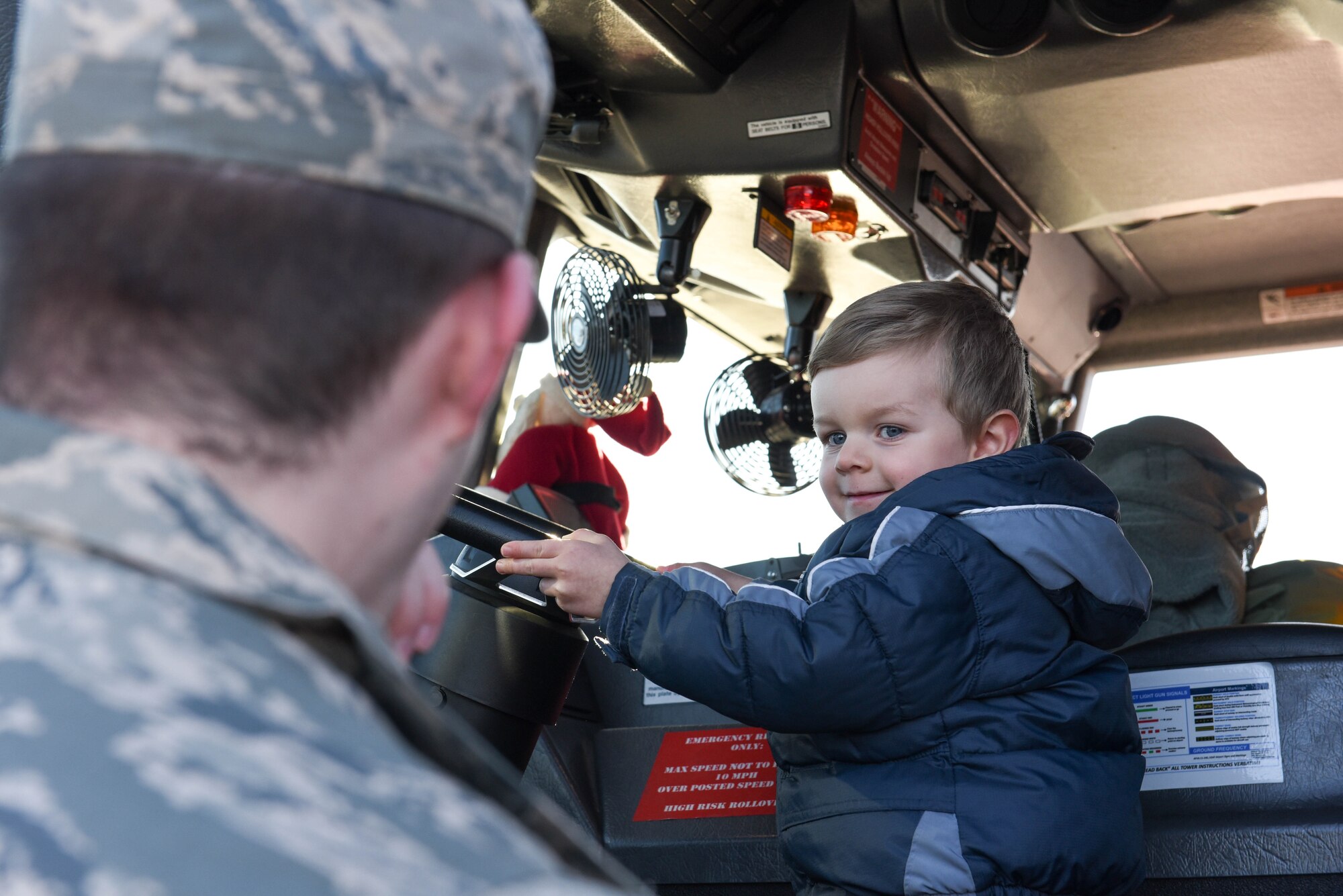 A child at Ellsworth Air Force Base, S.D., is given the chance sit in the front seat of a fire truck on Dec. 13, 2018. Following a “Santa and Me Story Time” event at the Holbrook Library, attendees were invited to the parking lot to tour a fire truck and visit with firefighters from the 28th Civil Engineer Squadron Fire Department. (U.S. Air Force photo by Airman John Ennis)