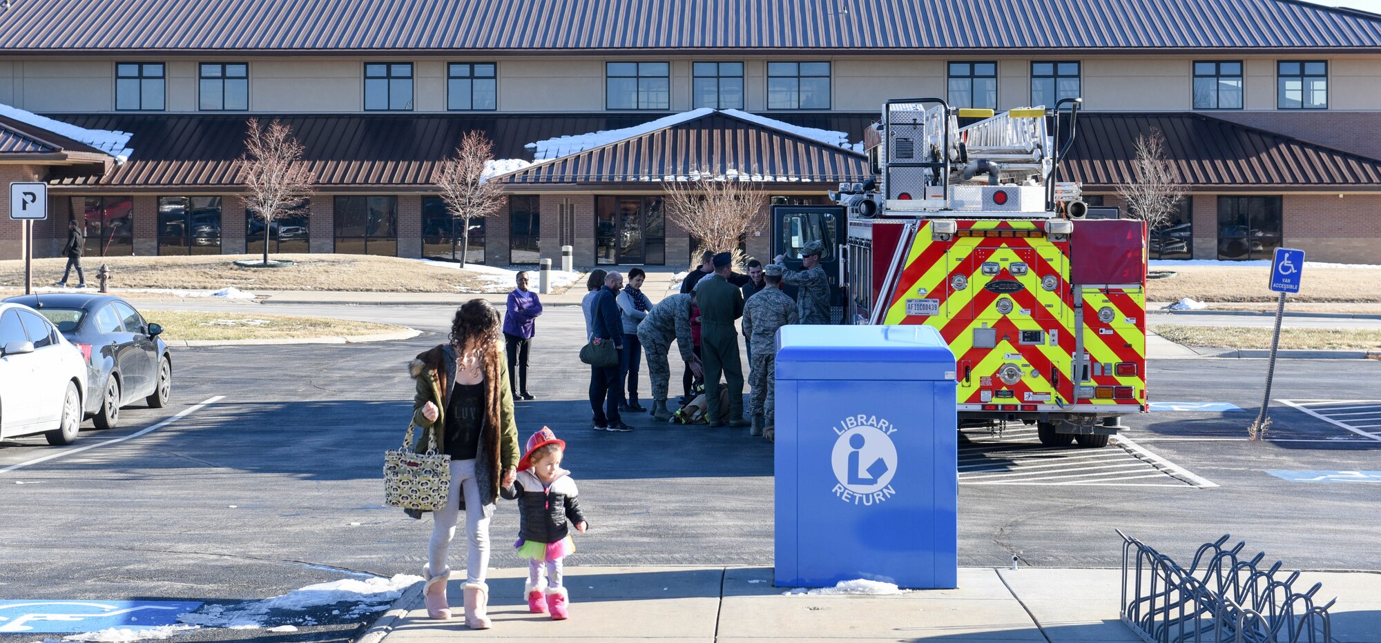 Members of the 28th Civil Engineer Squadron Fire Department visit with families on Ellsworth Air Force Base, S.D., on Dec. 13, 2018, following the conclusion of “Santa and Me Story Time” at the Holbrook Library. Firefighters escorted Santa Claus to the library earlier that day so he could read to the base’s children. After Santa left, the firefighters invited the Airmen and their families to tour a fire truck. (U.S. Air Force photo by Airman John Ennis)