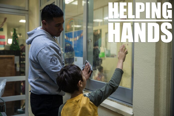Lance Cpl. Derek S. Pulu helps a student clean a window Dec. 14, 2018 at Ginowan City, Okinawa, Japan. Marines and Sailors with Combat Logistics Battalion 4, Combat Logistics Regiment 3, 3rd Marine Logistics Group, volunteered at the AmerAsian School in Okinawa to help with various beautification projects around the school. The school conducts triannual clean-up projects before each semester. Pulu, a native of American Samoa, is a motor transportation operator with Transportation Service Company, CLB-4, CLR-3, 3rd MLG. (U.S. Marine Corps photo by Lance Cpl. Armando Elizalde)