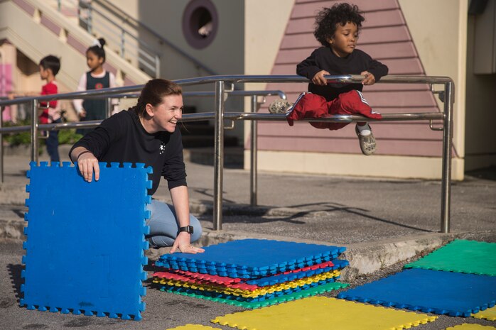 Lance Cpl. Alyssa J. Plunk, left, stacks foam squares Dec. 14, 2018 at Ginowan City, Okinawa, Japan. Marines and Sailors with Combat Logistics Battalion 4, Combat Logistics Regiment 3, 3rd Marine Logistics Group, volunteered at the AmerAsian School in Okinawa to help with various beautification projects around the school. The school conducts triannual clean-up projects before each semester. Plunk, a native of Marble Falls, Texas, is a motor transportation operator with Transportation Service Company, CLB-4, CLR-3, 3rd MLG. (U.S. Marine Corps photo by Lance Cpl. Armando Elizalde)