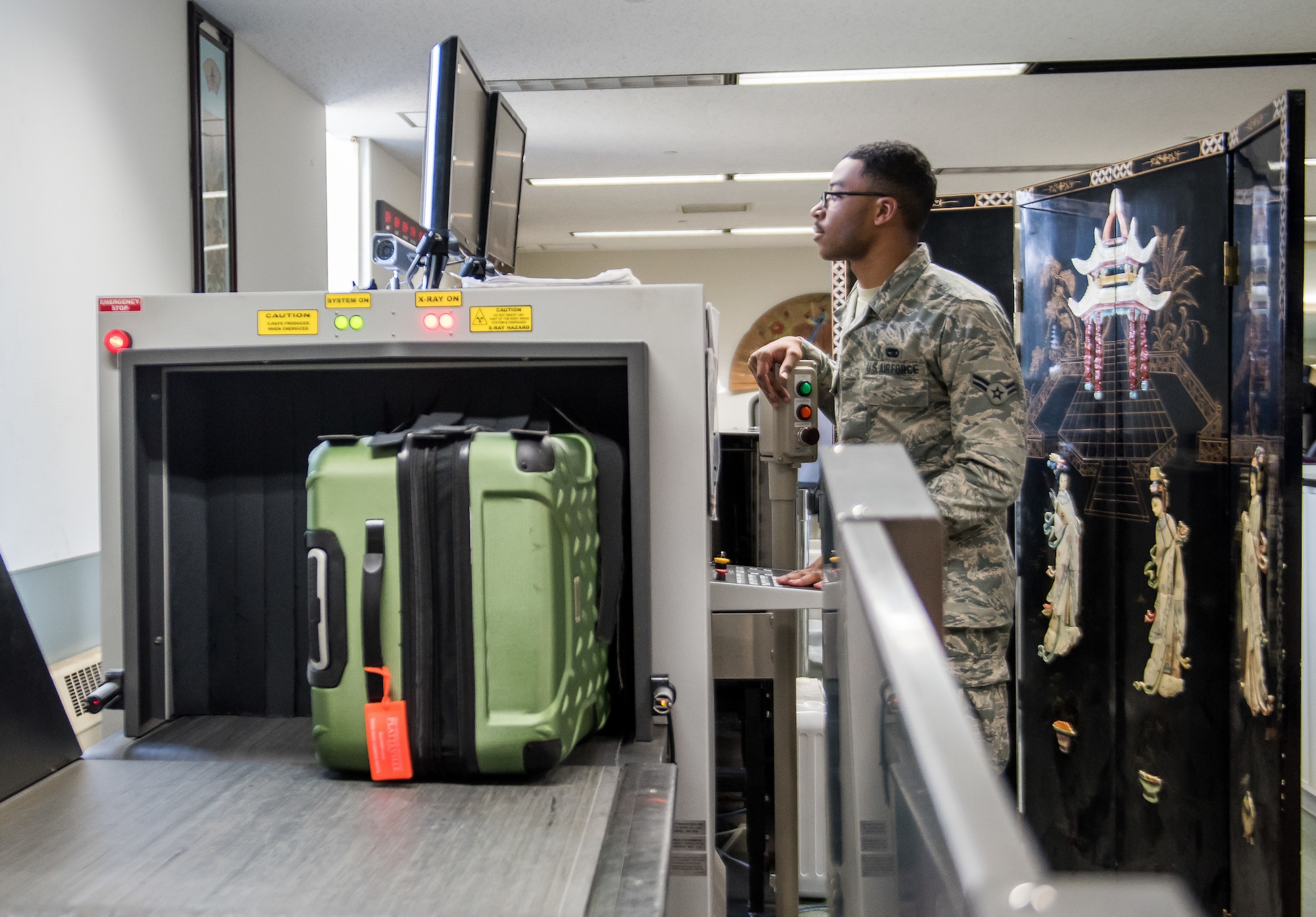 Airman 1st Class Malic Folwer, 730th Air Mobility Squadron passenger service agent, processes baggage through an x-ray machine