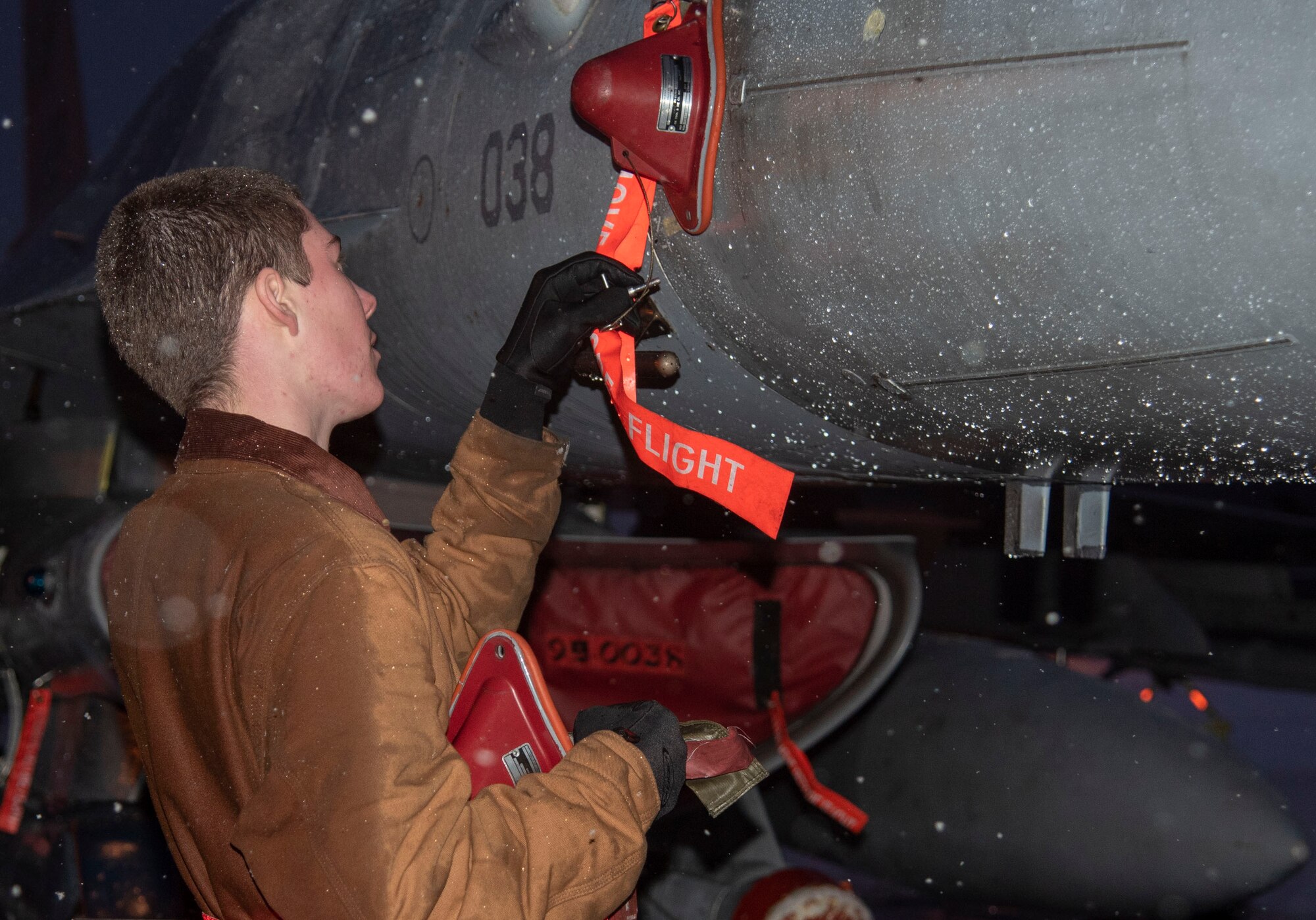 U.S. Air Force Airman 1st Class Avery Fortenbery, a 13th Aircraft Maintenance Unit crew chief, installs the lower pin on an F-16 Fighting Falcon at Misawa Air Base, Japan, Dec. 11, 2018. The aircraft-safe maintenance procedures communicate to the rest of the crew the aircraft is cleared to have post-flight maintenance work performed on it. (U.S. Air Force photo by Airman 1st Class Genesis Tejada)