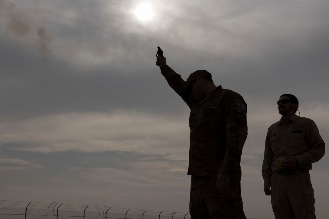 Tyler Adams, United States Department of Agriculture wildlife biologist, watches as Senior Master Sgt. Kenneth Riff, 443rd Air Expeditionary Squadron safety representative, fires off one of the pyrotecnics used to deter birds Dec. 3, 2018, at an undisclosed location in Southwest Asia. Although the main focus of this training was to deter animals, Airmen were also trained to maintain a list of all animals in their respected area, including endangered species.