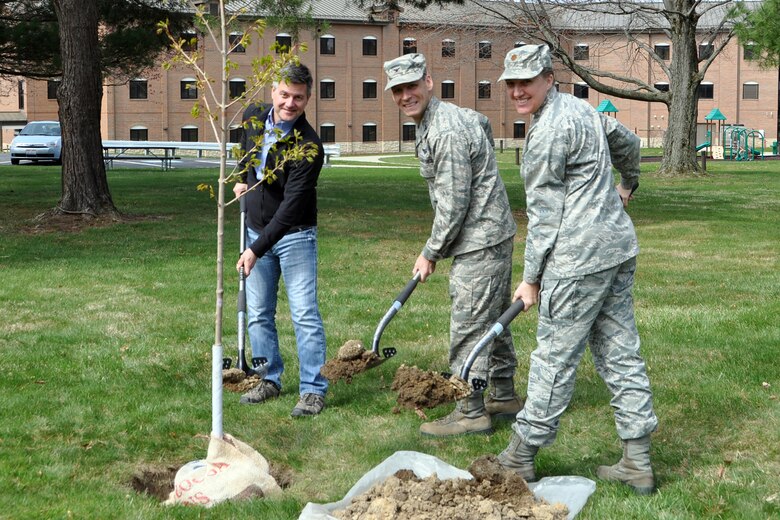 Brady McCann, an environmental engineer here, Col. Joe Janik, vice commander of the 910th Airlift Wing, and Maj. Wendy Strainic, executive officer for the 910th Airlift Wing, pose for a photo while planting a tree on the installation grounds, April 27, 2018.