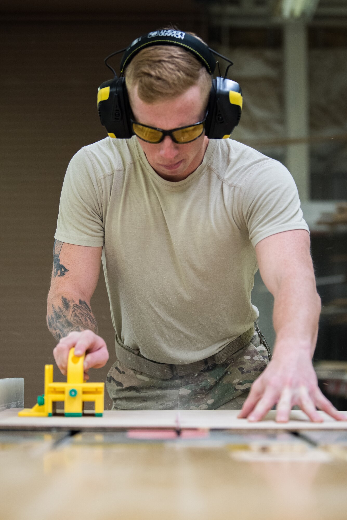 Senior Airman Dawson White, 27th Special Operations Civil Engineer Squadron structural journeyman, saws a piece of plywood for a project at Cannon Air Force Base, New Mexico, Dec. 12, 2018. To prevent injury, tools like a push block are used to safely move wood across a table saw. (U.S. Air Force photo by Airman 1st Class Vernon R. Walter III)