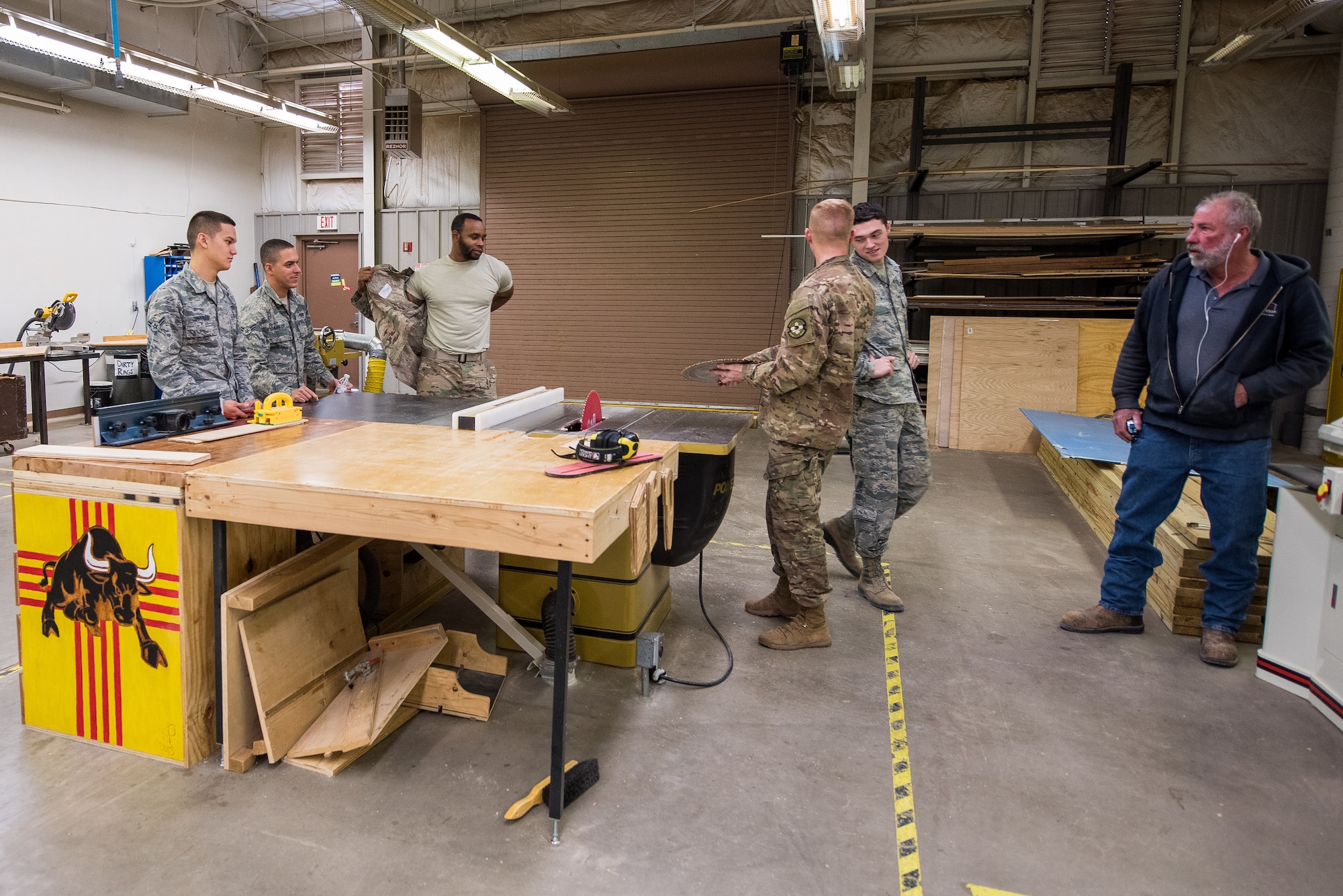 Members of the 27th Special Operations Civil Engineer Squadron structures shop have a briefing on how to properly replace a table saw blade at Cannon Air Force Base, New Mexico, Dec. 12, 2018. When a table saw is not powered on, Airmen still practice proper safety techniques as if it was. (U.S. Air Force photo by Airman 1st Class Vernon R. Walter III)