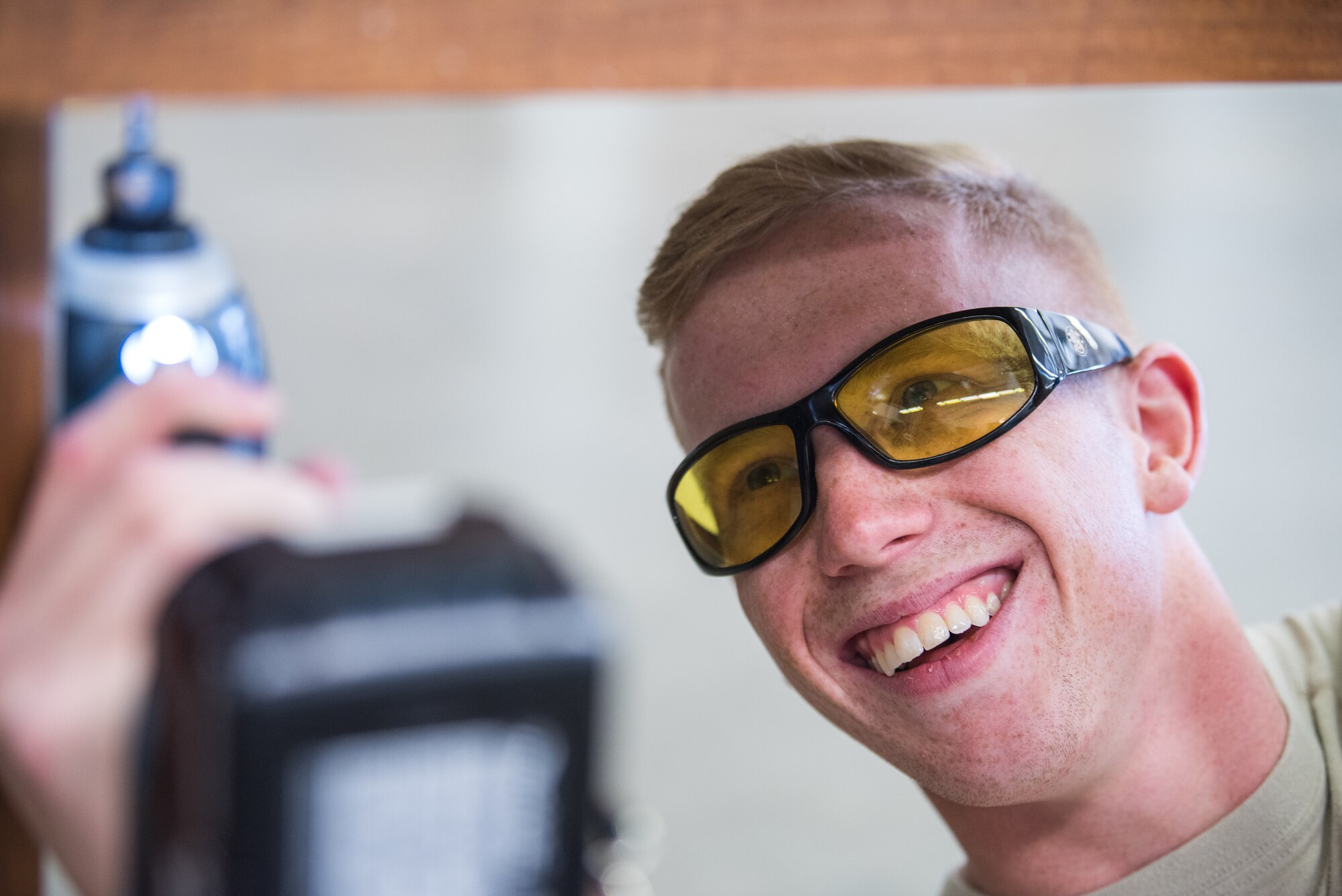 Senior Airman Dawson White, 27th Special Operations Civil Engineer Squadron structural journeyman, laughs while drilling in a replacement screw at Cannon Air Force Base, New Mexico, Dec. 12, 2018. When working, proper eye protection must be worn to prevent injury. (U.S. Air Force photo by Airman 1st Class Vernon R. Walter III)