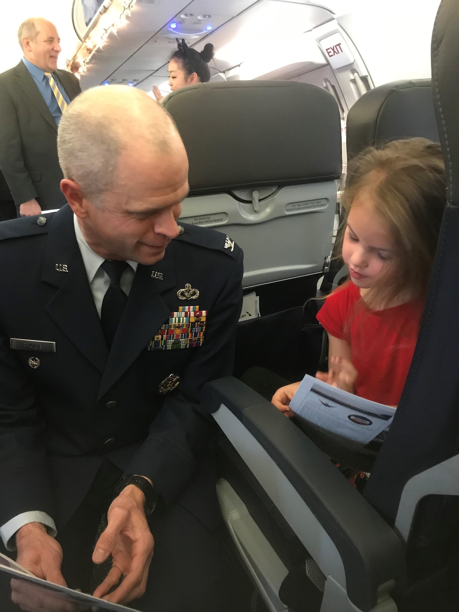 Col. Deron Frailie, 75th Air Base Wing vice commander, visits with a Gold Star child about her trip to Walt Disney World when the Snowball Express returned to Salt Lake City International Airport Dec. 12, 2018. (Courtesy photo by Jennifer Eaton)