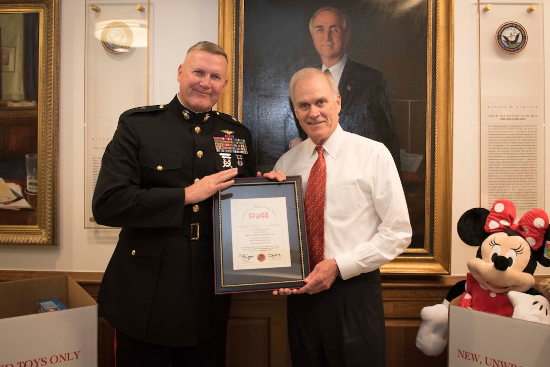 SECNAV Richard Spencer receiving Toys for Tots Commanders Award from CMFR at the annual SECNAV Holiday Party.