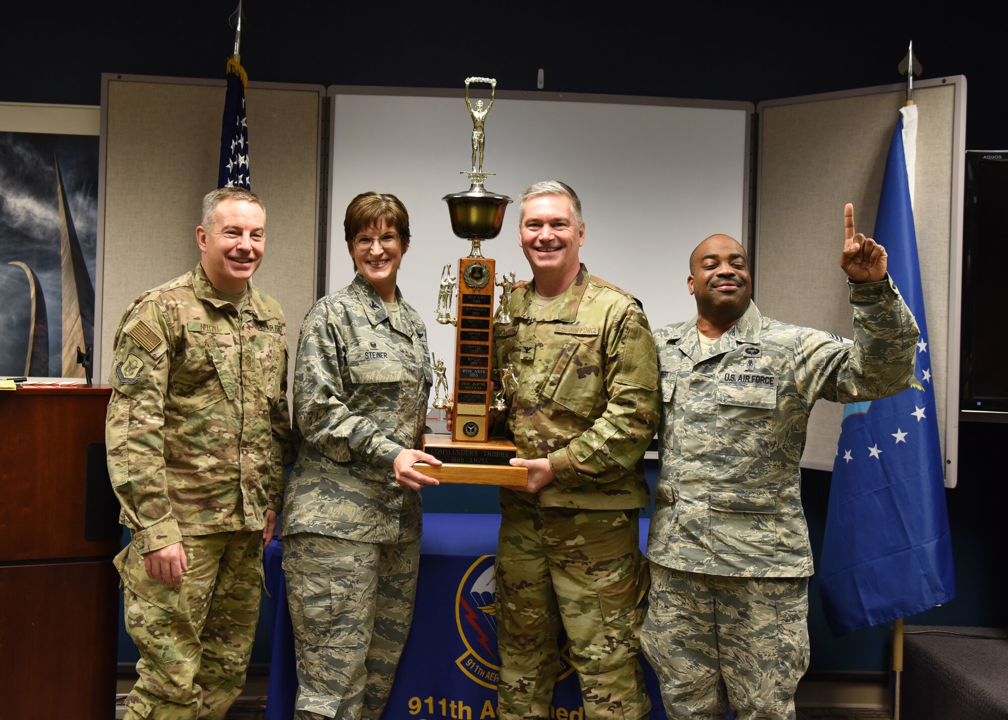 Col. Douglas N. Strawbridge, commander of the 911th Airlift Wing, Col. Karen Steiner, commander of the 911th Aeromedical Staging Squadron, Chief Master Sgt. Christopher D. Neitzel, Command Chief of the 911th Airlift Wing, and Chief Master Sgt. Philip Gilbert, and superintendent of the 911th ASTS, pose for a photo at the Pittsburgh International Airport Air Reserve Station, Pennsylvania, December 2, 2018. Strawbridge presented the Commander’s Trophy award to Steiner, which she received on behalf of all of the ASTS Airmen who participated in the wing intramural sports competition. (U.S. Air Force Photo by Senior Airman Grace Thomson)