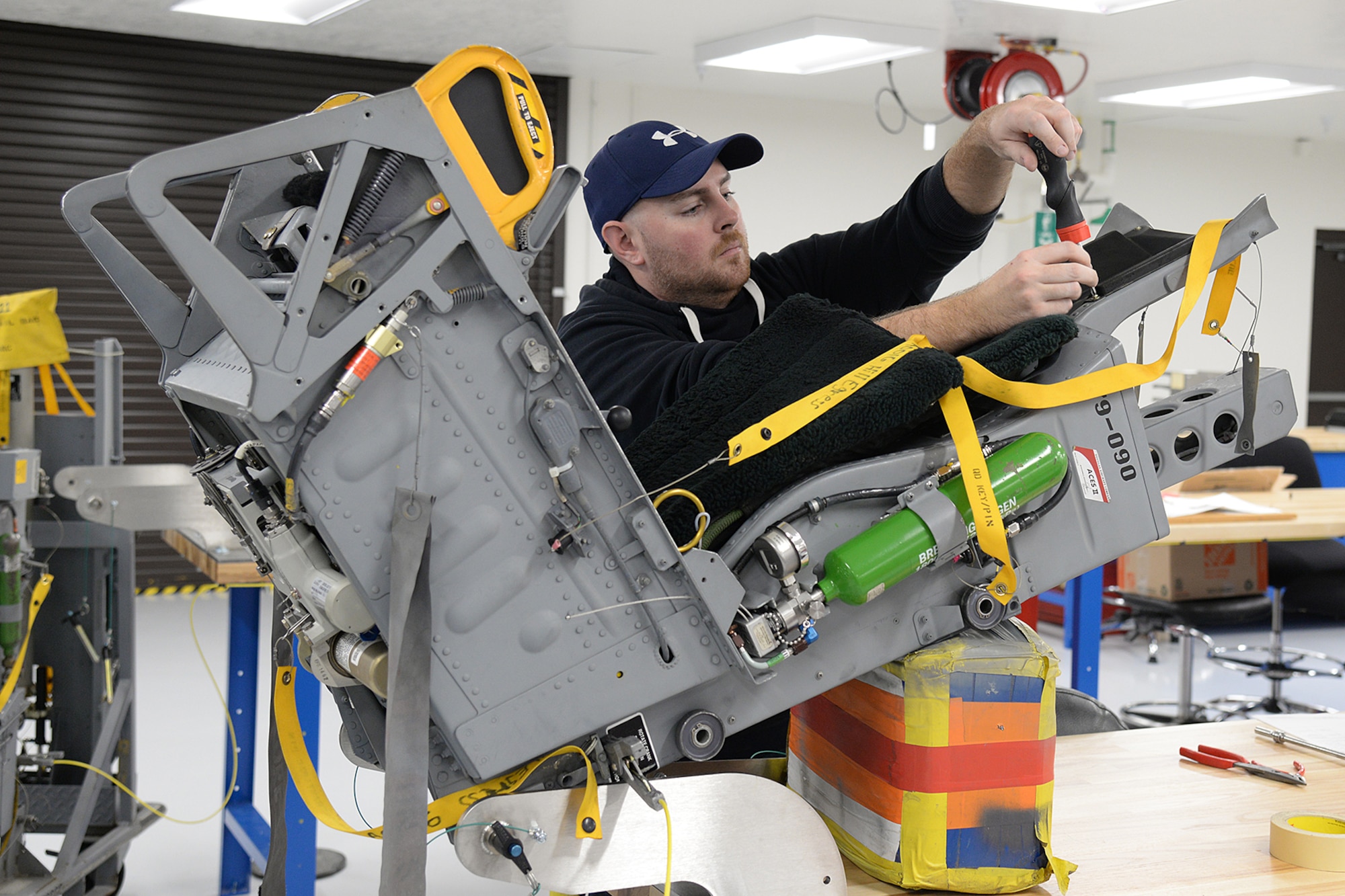 Sean Donnelly, 576th Aircraft Maintenance Squadron technician, installs a head rest assembly on an ACES II ejection seat Dec. 12, 2018, at Hill Air Force Base, Utah. The 576th AMXS opened the doors of its new egress repair facility that includes an expanded working area with an administration section, training section, tool room, explosive storage, and three separate work areas to separate the ACES II seat repairs from the F-35 Martin-Baker seat repairs. (U.S. Air Force photo by Alex R. Lloyd)