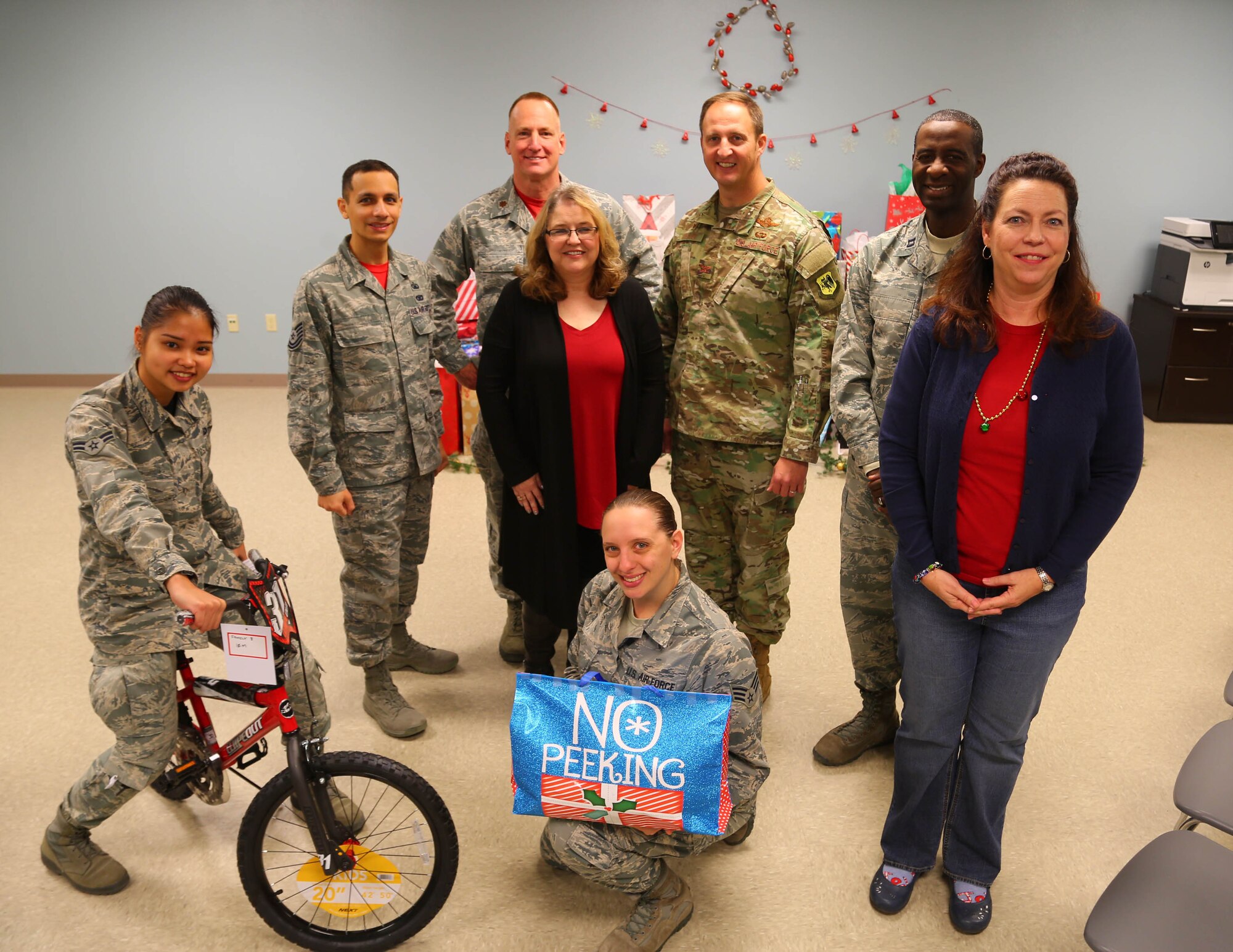 Col. Julian Cheater, 432nd Wing/432nd Air Expeditionary Wing  commander, Kimberly Guerino, Indian Springs School registrar, and Kelly Miles, Indian Springs School counselor, gather for a photo with members of the Human Performance Team and Airmen volunteers who collected, wrapped and coordinated delivery of gifts for Indian Springs Schools students at Creech Air Force Base, Nevada, Dec. 14, 2018. During the past seven years, Creech Airmen have donated roughly 800 presents to children in the local area during the Holidays. (U.S. Air Force photo by Tech. Sgt. Dillon White)