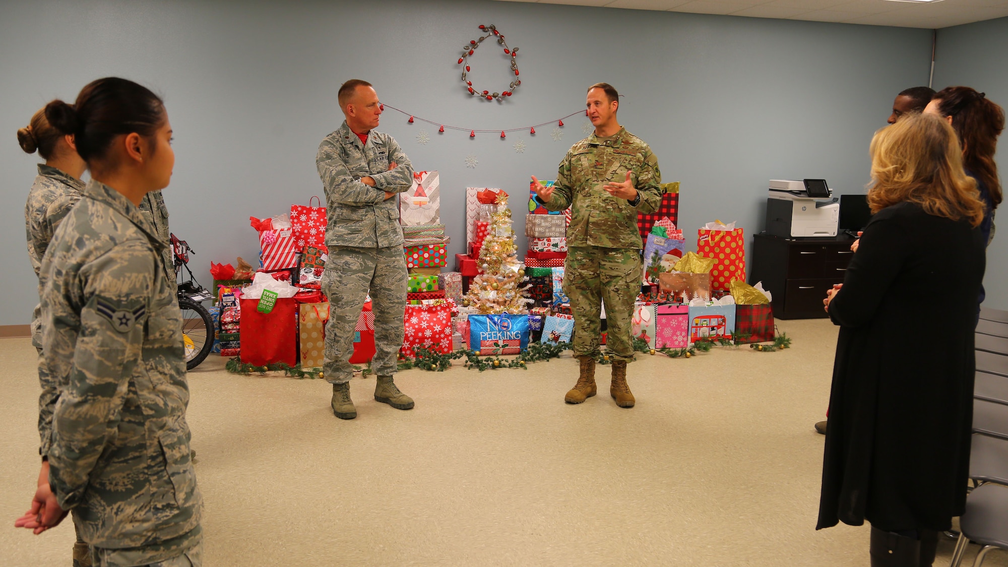 (Center) Col. Julian Cheater, 432nd Wing/432nd Air Expeditionary Wing commander, thanks Airmen volunteers at Creech Air Force Base, Nevada, for their hard work in collecting, wrapping and coordinating delivery of donated gifts for students attending Indian Springs Schools Dec. 14, 2018. Kimberly Guerino, Indian Springs Schools registrar, and Kelly Miles, Indian Springs Schools counselor, accepted the gifts on behalf of their students. (U.S. Air Force photo by Tech. Sgt. Dillon White)