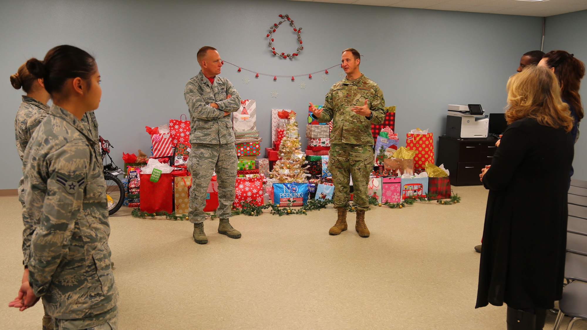 (Center) Col. Julian Cheater, 432nd Wing/432nd Air Expeditionary Wing commander, thanks Airmen volunteers at Creech Air Force Base, Nevada, for their hard work in collecting, wrapping and coordinating delivery of donated gifts for students attending Indian Springs Schools Dec. 14, 2018. Kimberly Guerino, Indian Springs Schools registrar, and Kelly Miles, Indian Springs Schools counselor, accepted the gifts on behalf of their students. (U.S. Air Force photo by Tech. Sgt. Dillon White)