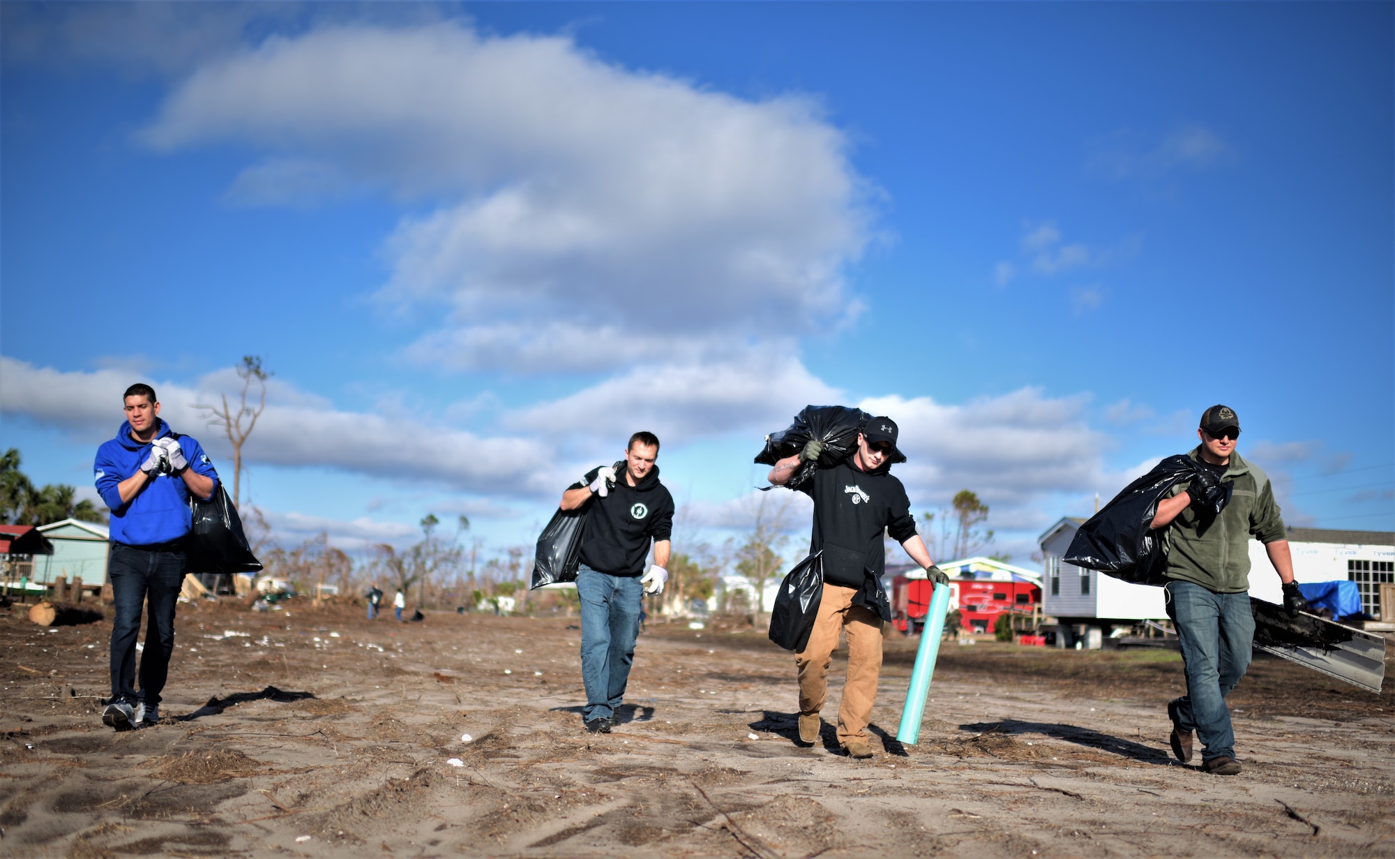 Airman from Tyndall Air Force Base carry bags of debris while carrying bags of trash while cleaning debris from Under the Palms Park in Mexico Beach, Fla., Dec. 16, 2018. Thirty nine volunteers from Tyndall and Eglin Air Force Bases came together to help clean Mexico Beach, one of the communities hit the hardest by Hurricane Michael.  The volunteers were able to clean up more than 40 cubic yards of debris within four hours. (U.S. Air Force photo by Tech. Sgt. Sara Keller)