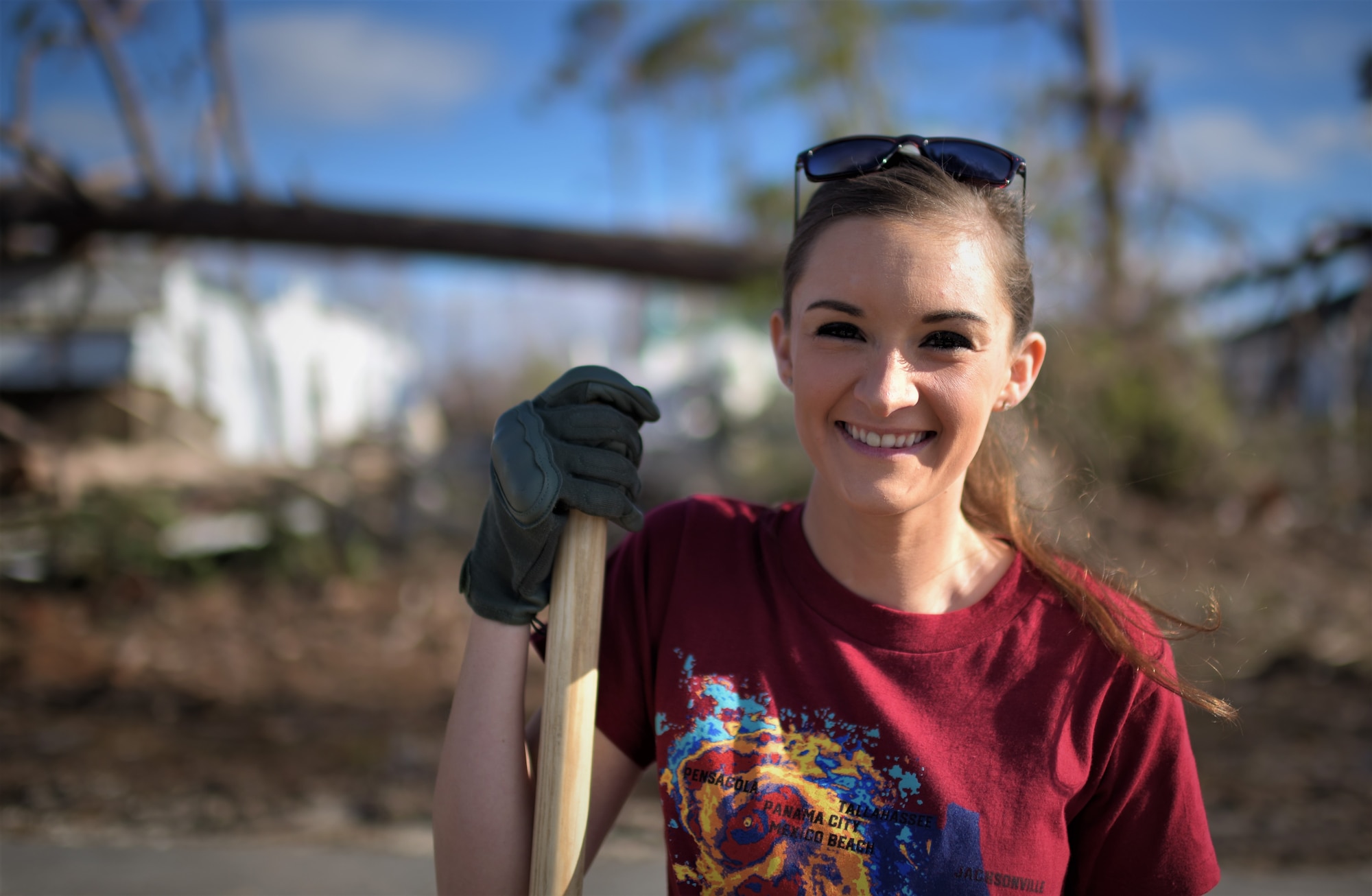 Senior Airman Megan Timbers, 325th Force Support Squadron readiness and plans and event coordinator, stands in front of a broken tree line at Under the Palms Park in Mexico Beach, Fla., Dec. 16, 2018. Timbers helped recruit volunteers from Tyndall and Eglin Air Force Bases to come together to help clean Mexico Beach, one of the communities hit the hardest by Hurricane Michael.  The volunteers were able to clean up more than 40 cubic yards of debris within four hours. (U.S. Air Force photo by Tech. Sgt. Sara Keller)