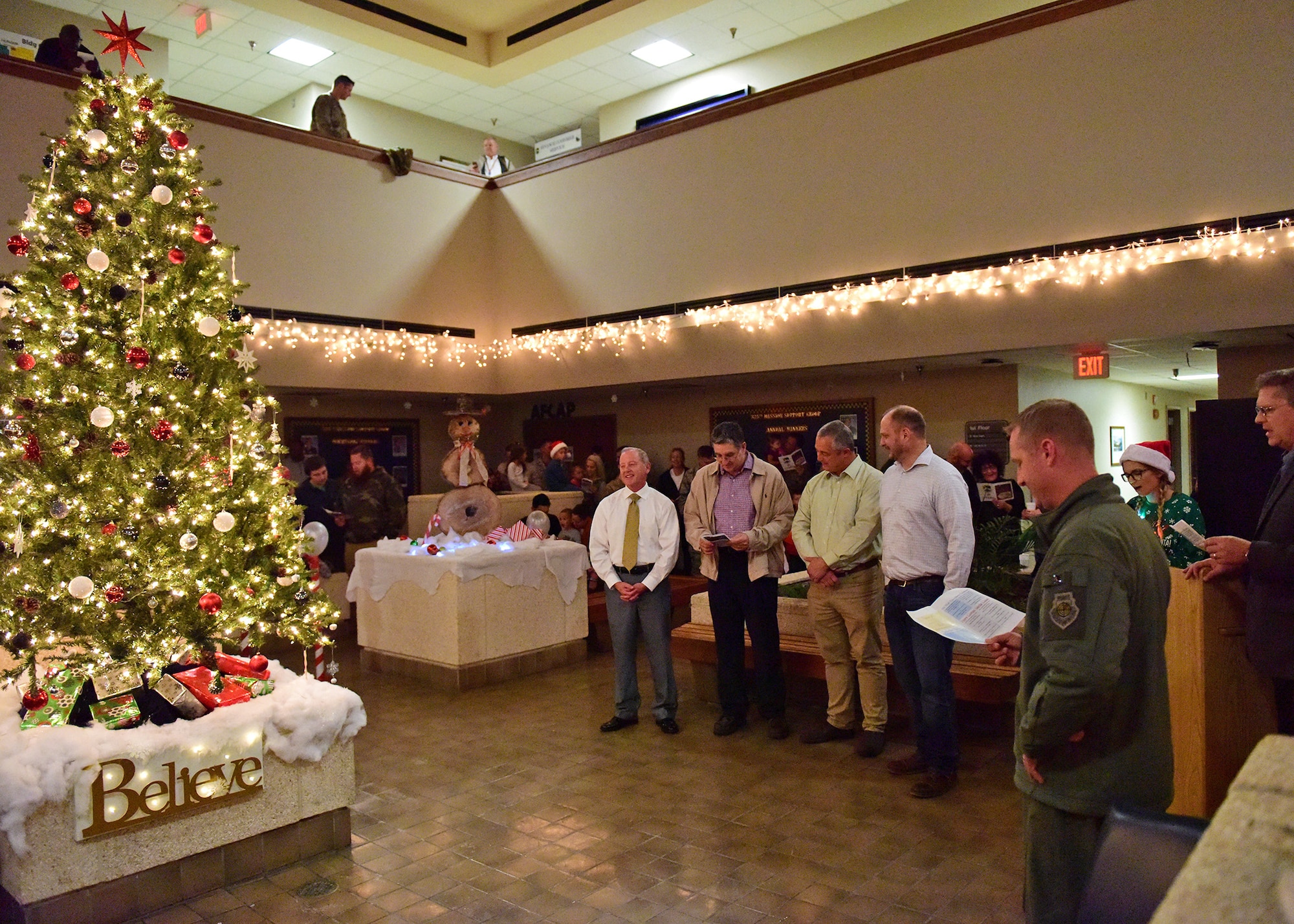 Col. Brian Laidlaw, 325th Fighter Wing commander, right, is joined by local civic leaders in singing holiday songs at the 75th Annual Christmas Tree Lighting ceremony at Tyndall Air Force Base, Fla., Dec. 14, 2018. The ceremony included an invocation, comments by the commander, the tree lighting, and Christmas sing along paired with the arrival of Santa Clause. (U.S. Air Force photo Senior Airman Isaiah J. Soliz)