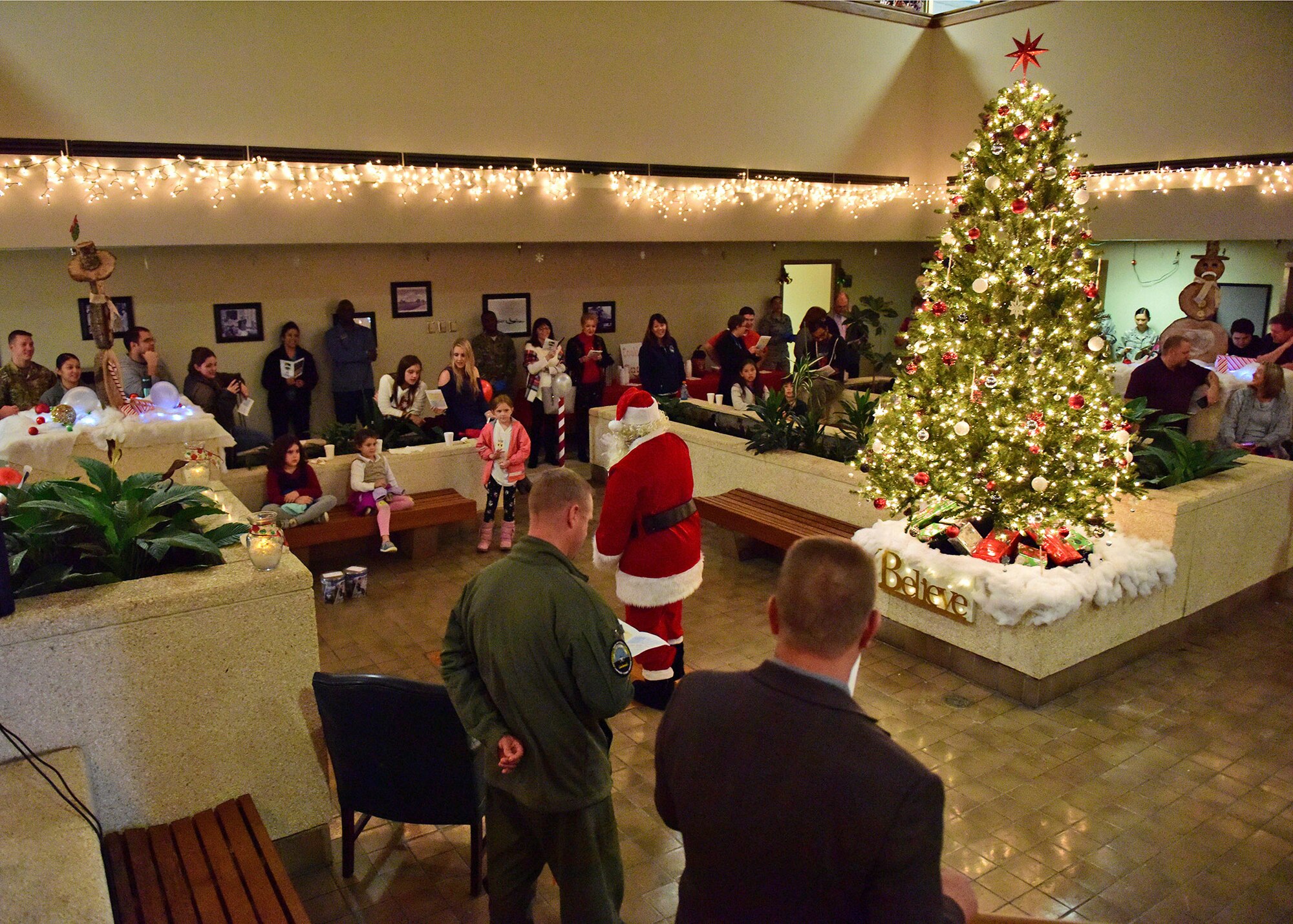 Santa Clause greets children as members of Team Tyndall sing along to Christmas songs during the 75th Annual Christmas Tree Lighting ceremony at Tyndall Air Force Base, Fla., Dec. 14, 2018. The ceremony included an invocation, comments by the commander, the tree lighting, and Christmas sing along paired with the arrival of Santa Clause. (U.S. Air Force photo Senior Airman Isaiah J. Soliz)